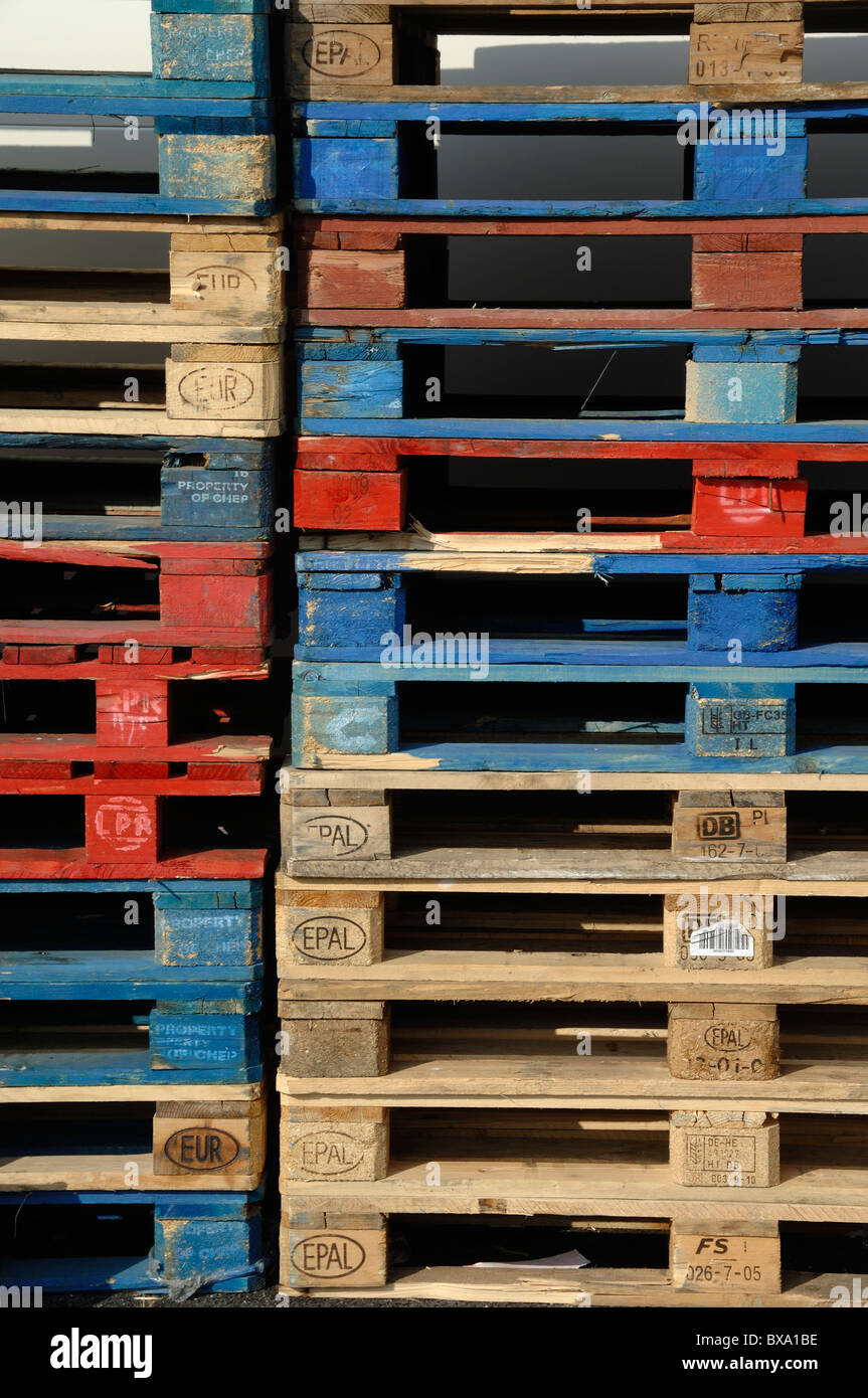 Pile or Stack of Red and Blue Coloured Wooden Pallets, Timber Pallets or Europallets Stock Photo