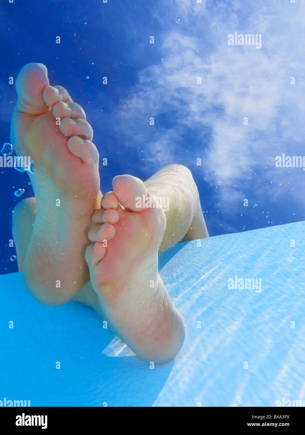 Woman sitting with her feet in the swimming pool Stock Photo - Alamy