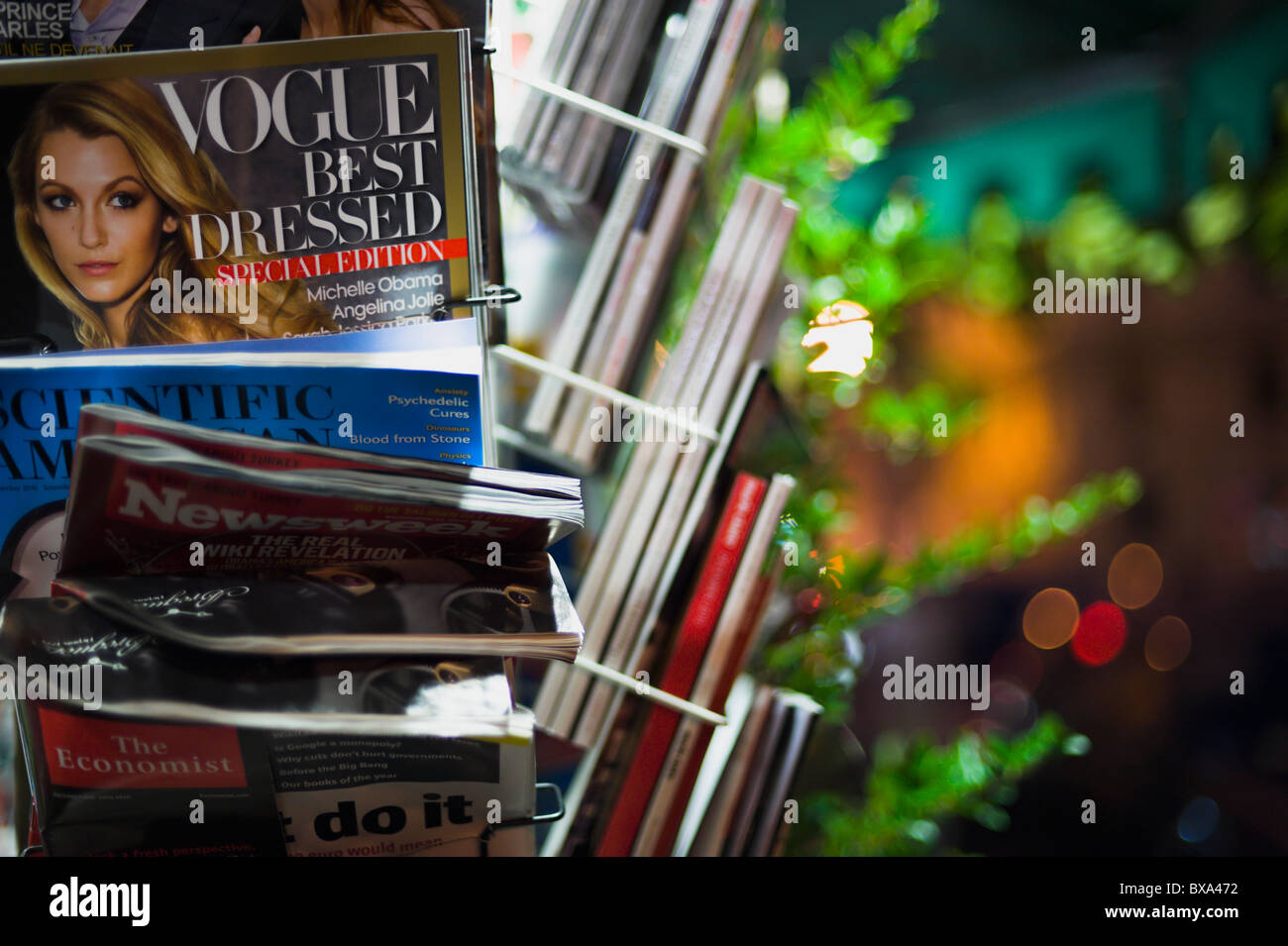 Vogue, Scientific American, Newsweek, The Economist, magazines for sale at a newsstand, by night, shallow DOF Stock Photo