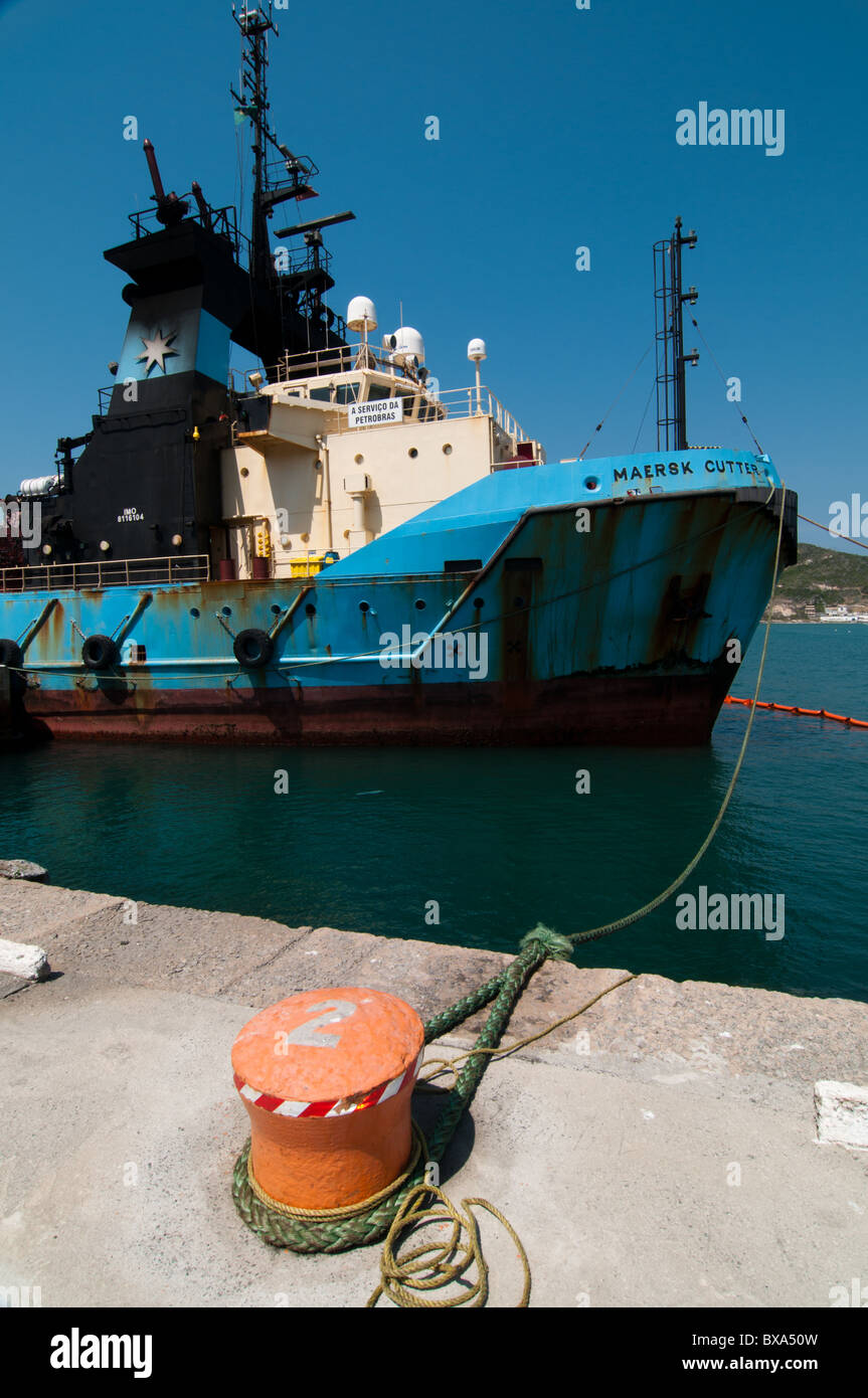 Supply Vessel Maersk Cutter anchored on Arraial do Cabo port, Rio de Janeiro, Brazil, surrounded by an oil spill barier. Stock Photo