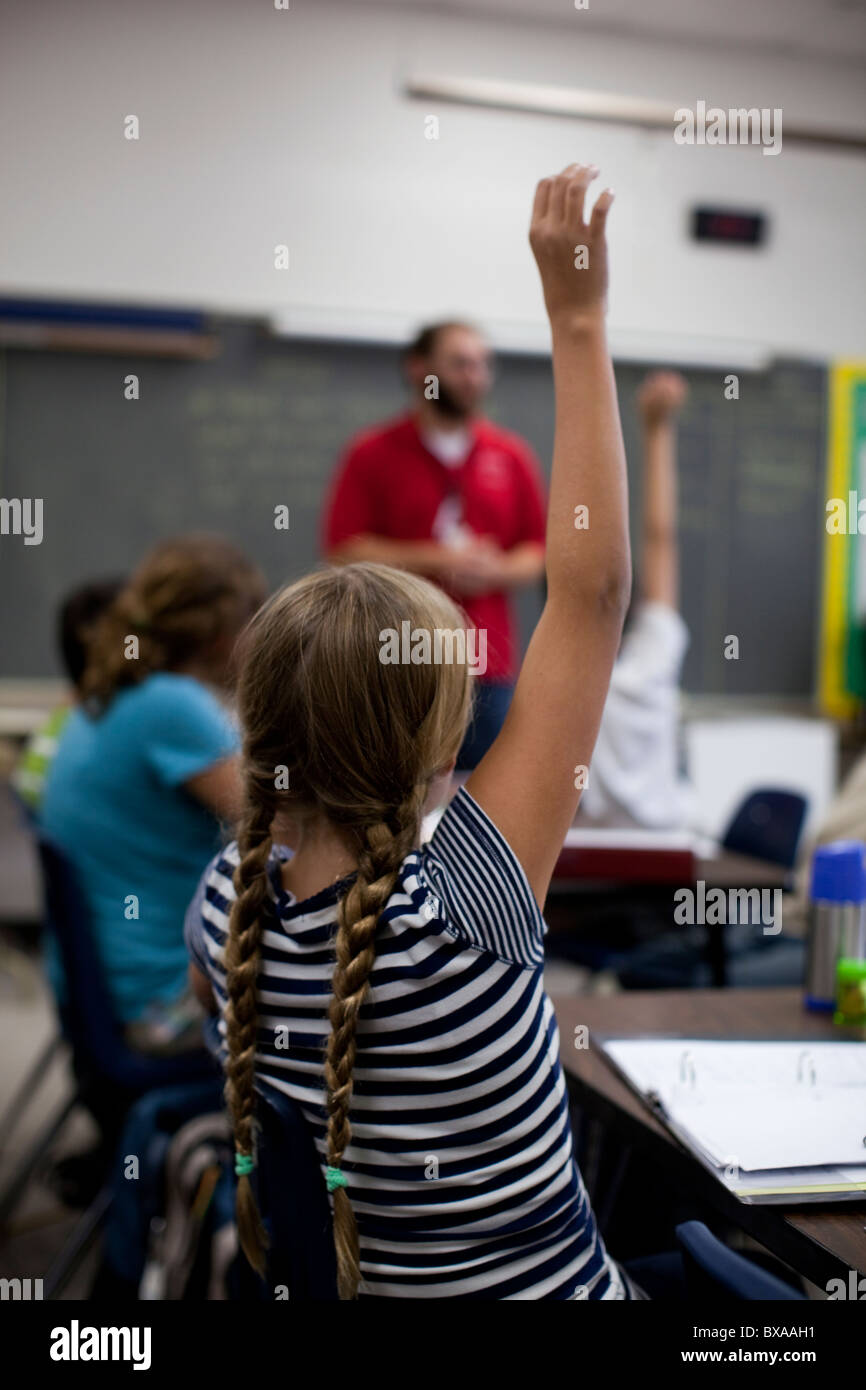 Students raise their hands to answer question in social studies class