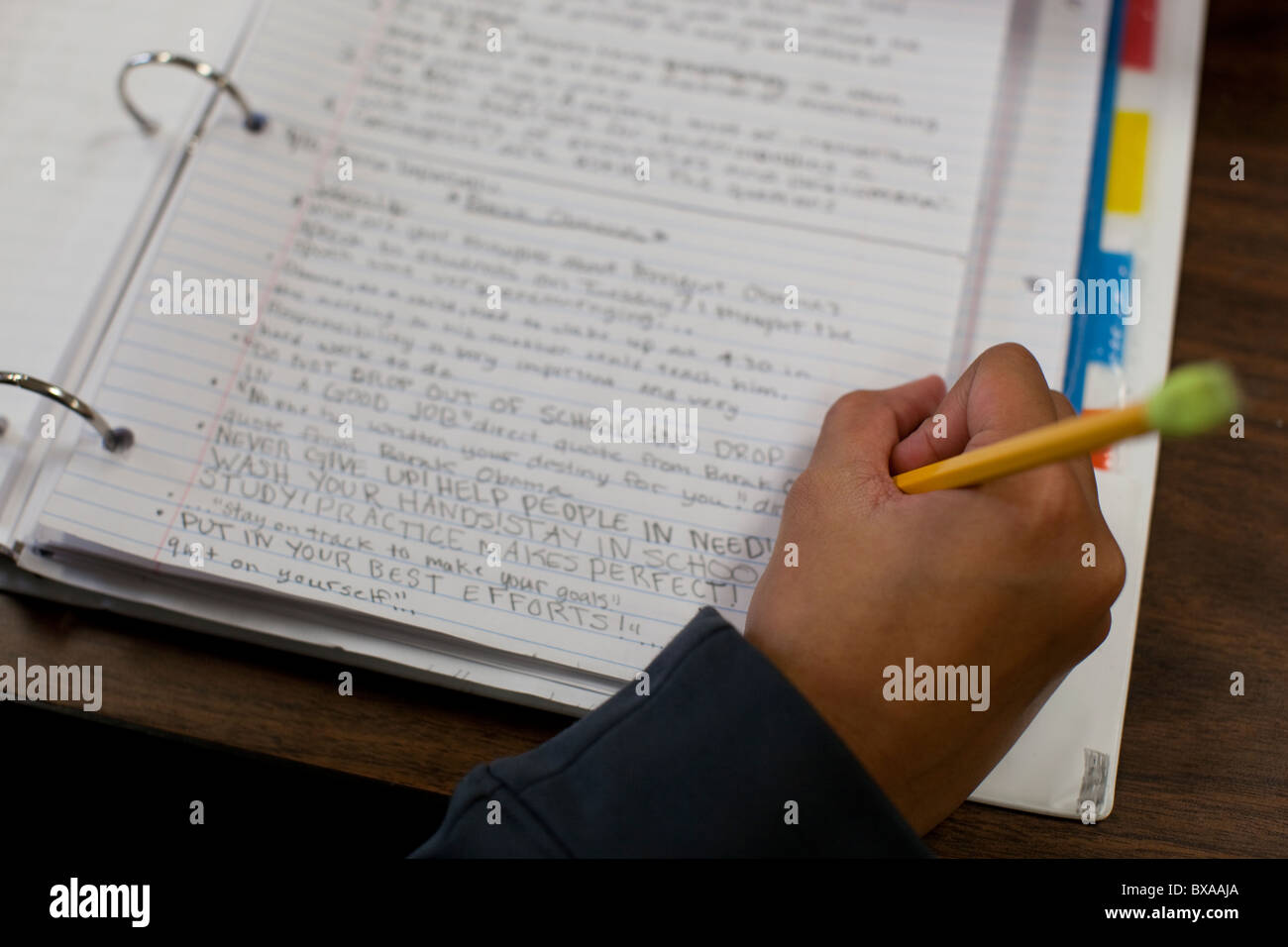 Right-handed student  uses a pencil with eraser to write in binder during social studies class at Kealing Middle School Stock Photo
