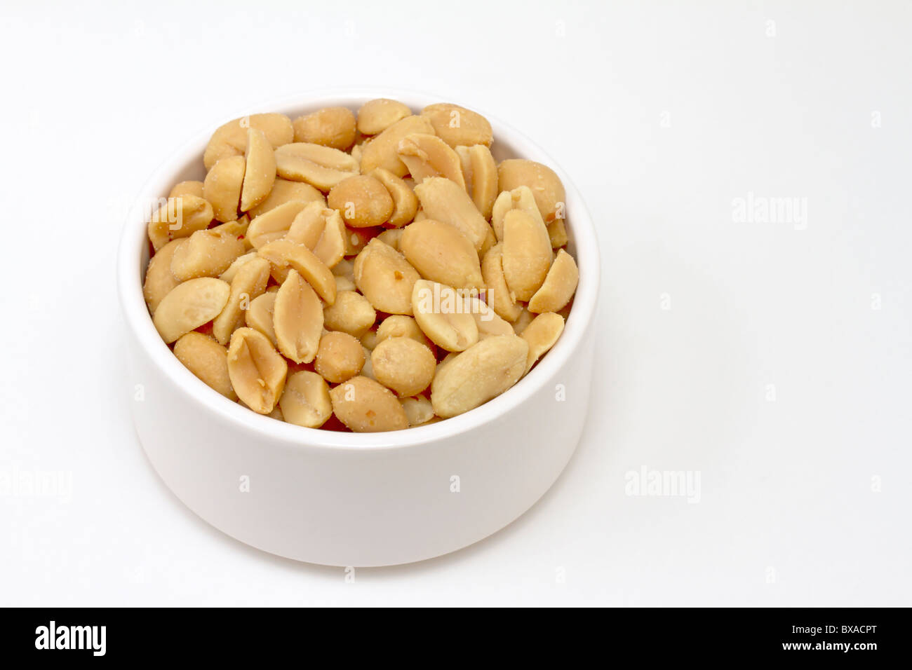 Small white bowl of salted peanuts Stock Photo