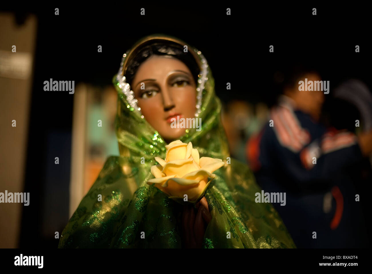 A statue of Our Lady of Guadalupe Virgin is decorated with a yellow