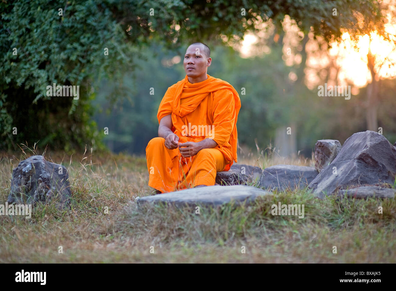 A monk sitting on a stone, Angkor, Cambodia Stock Photo