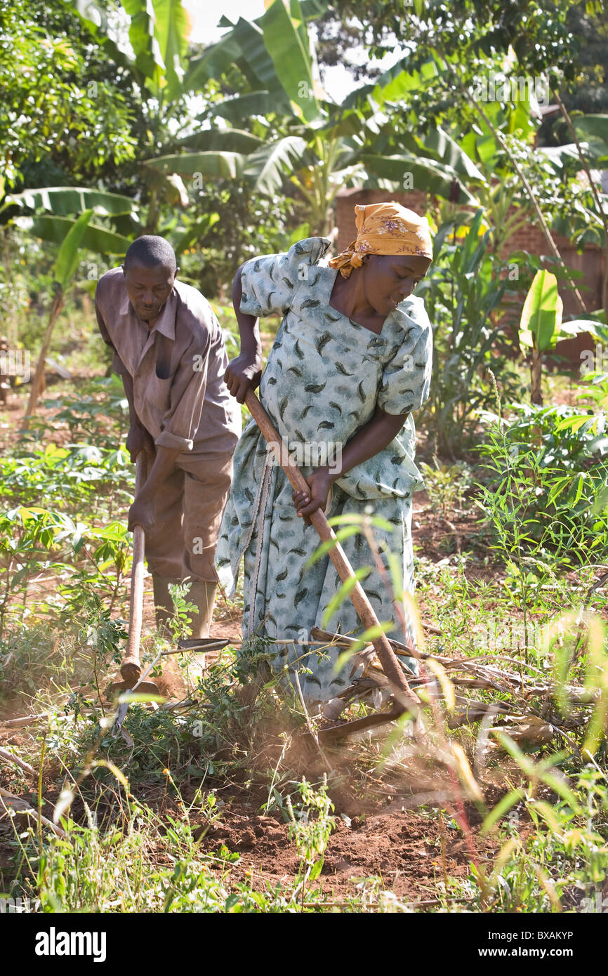 A couple farms in their garden in Iganga, Uganda, East Africa. Stock Photo
