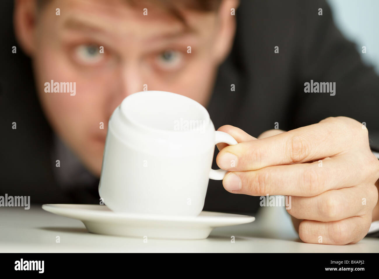 Young businessman makes predictions using coffee grounds - close up Stock Photo