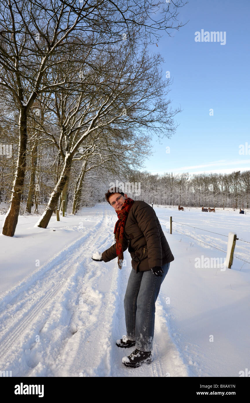 Senior woman trhowing a snowball Stock Photo