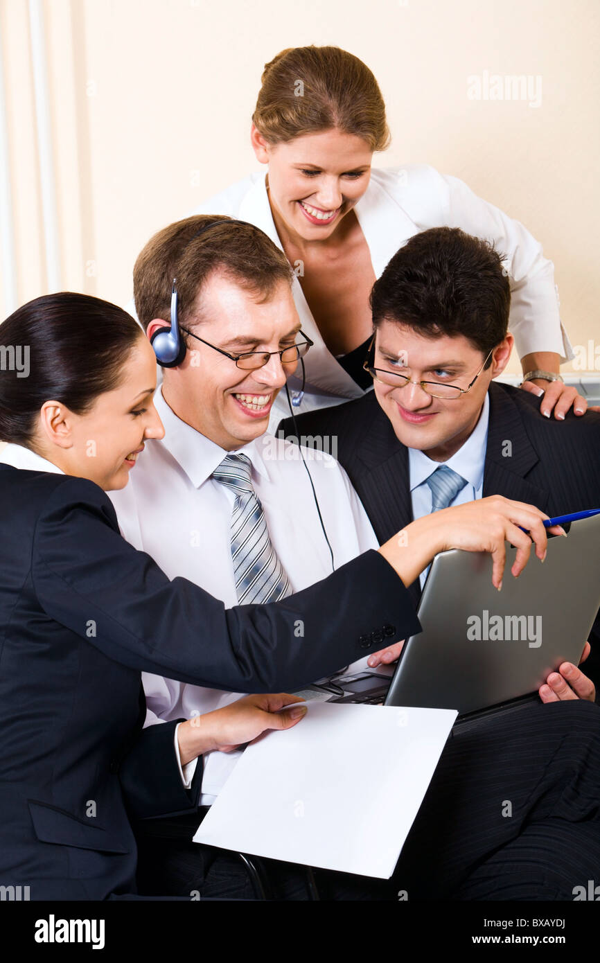 Young successful business people gathered together around the laptop ...