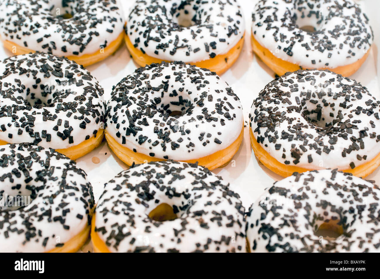 White glazed doughnuts with chocolate sprinkles Stock Photo