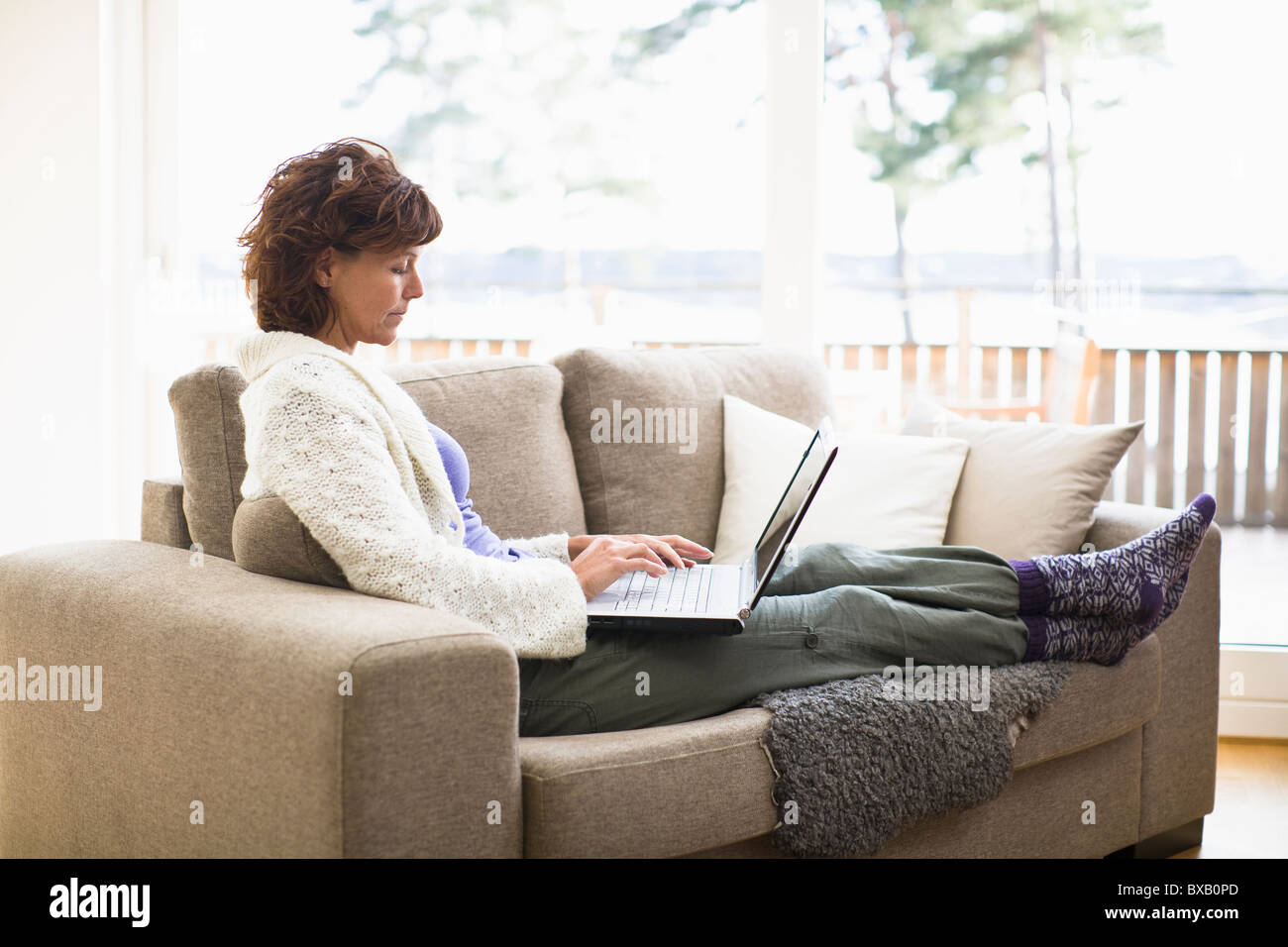 Casual woman sitting on sofa hi-res stock photography and images - Alamy