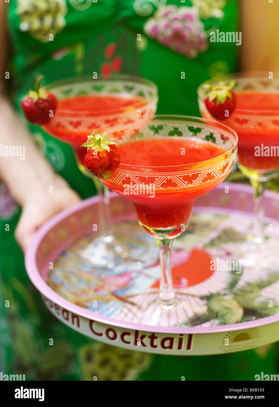Close-up of person holding tray of strawberry drink Stock Photo
