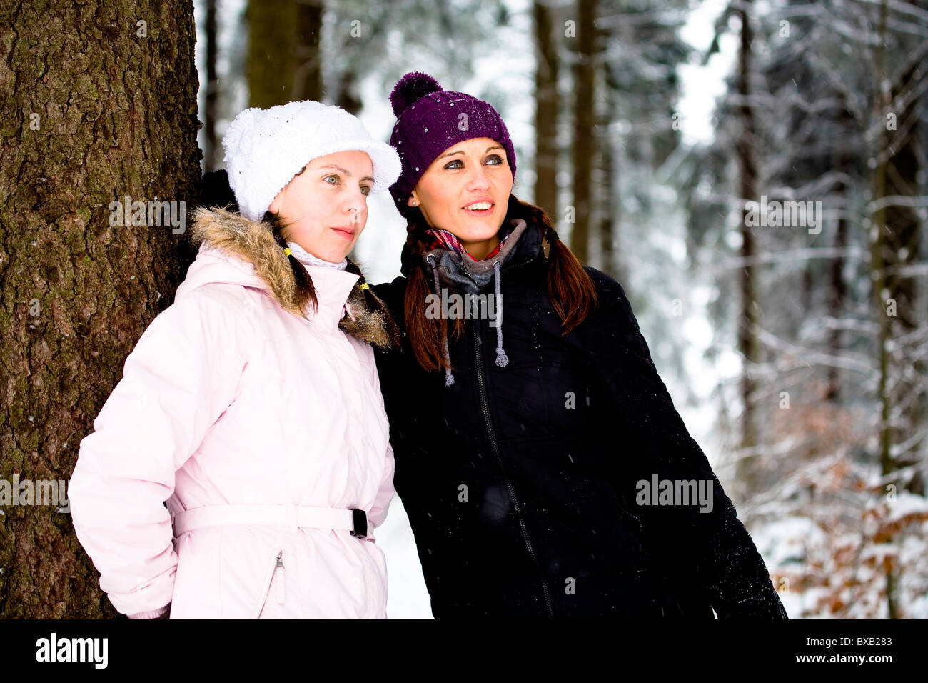 Two young women in a winter forest Stock Photo - Alamy