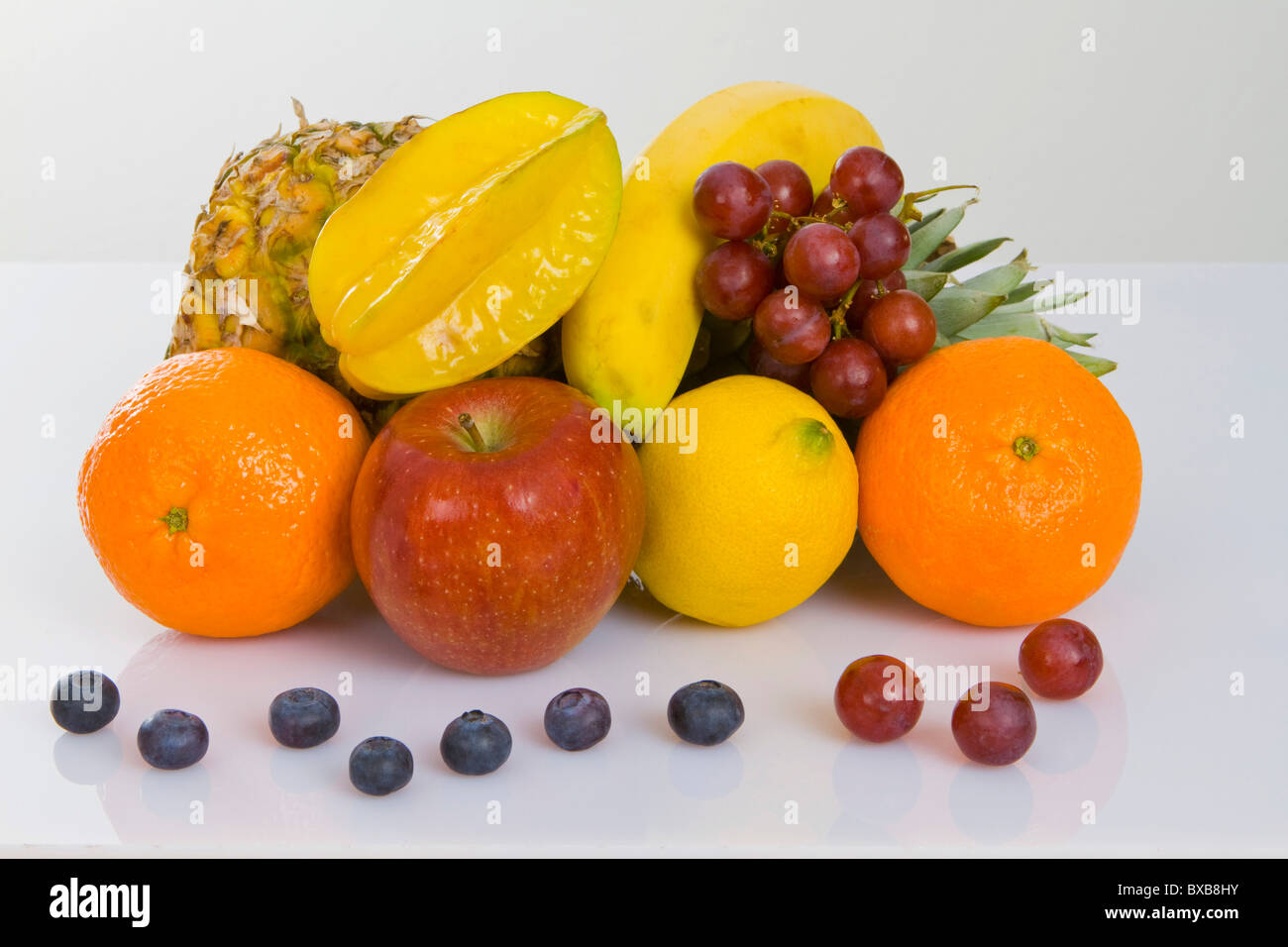 Pineapple, apple, clementines, lemon, star fruit, blueberries and red grapes Stock Photo