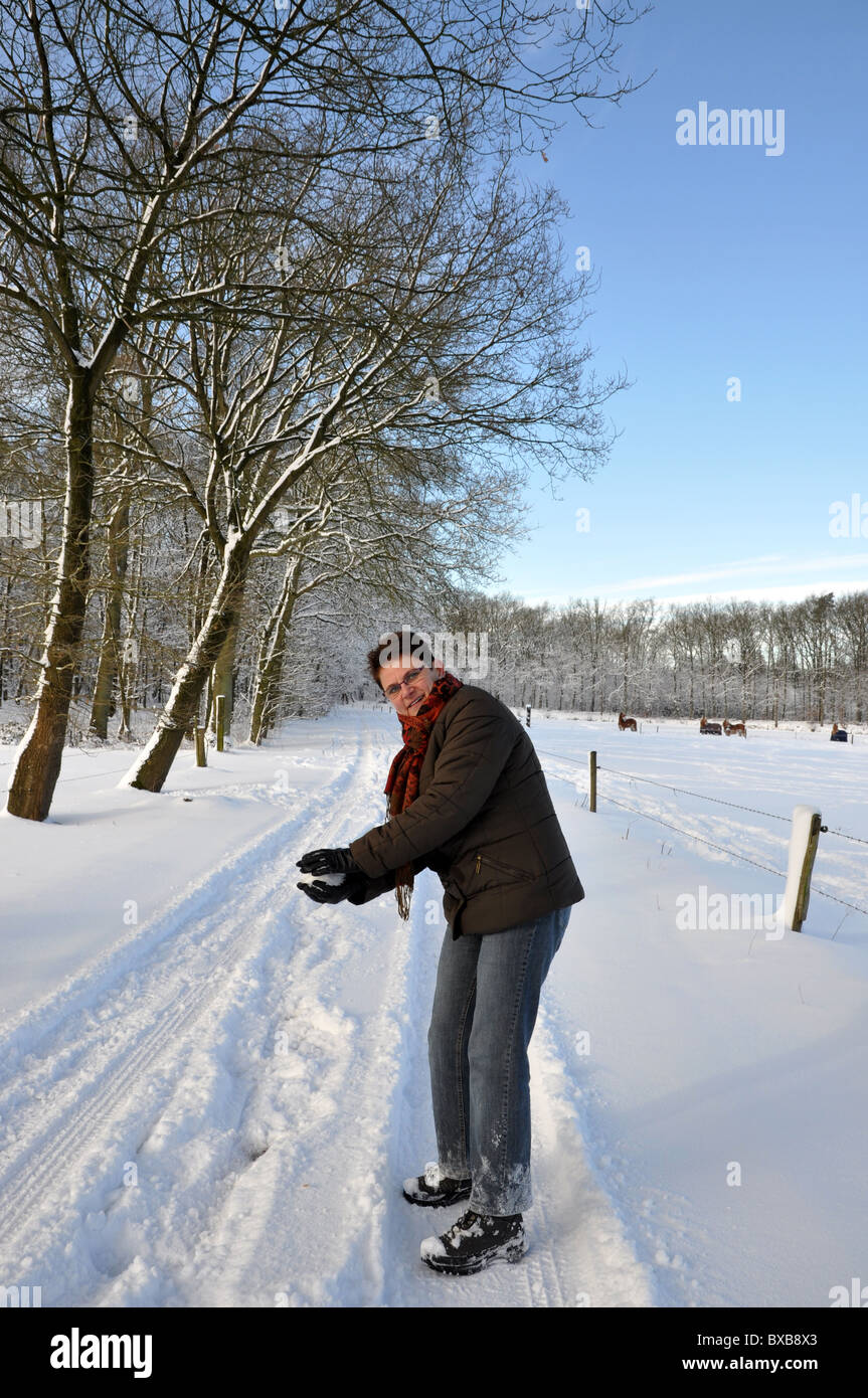 Senior keeping fit by throwing snowballs Stock Photo