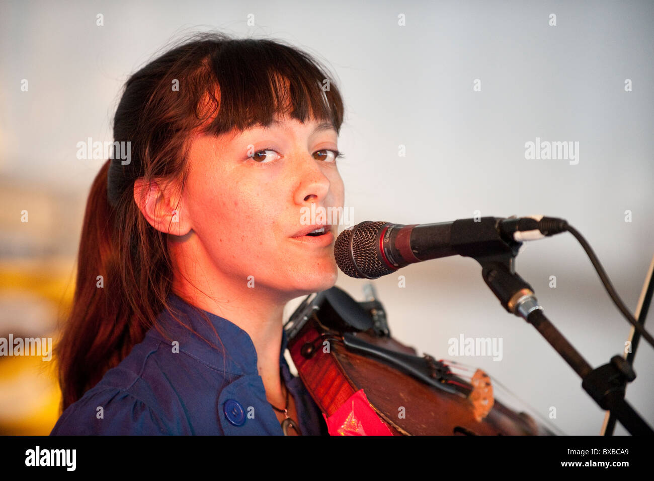 Female fiddle player sings into microphone during show in entertainment tent at Texas Book Festival in Austin Stock Photo