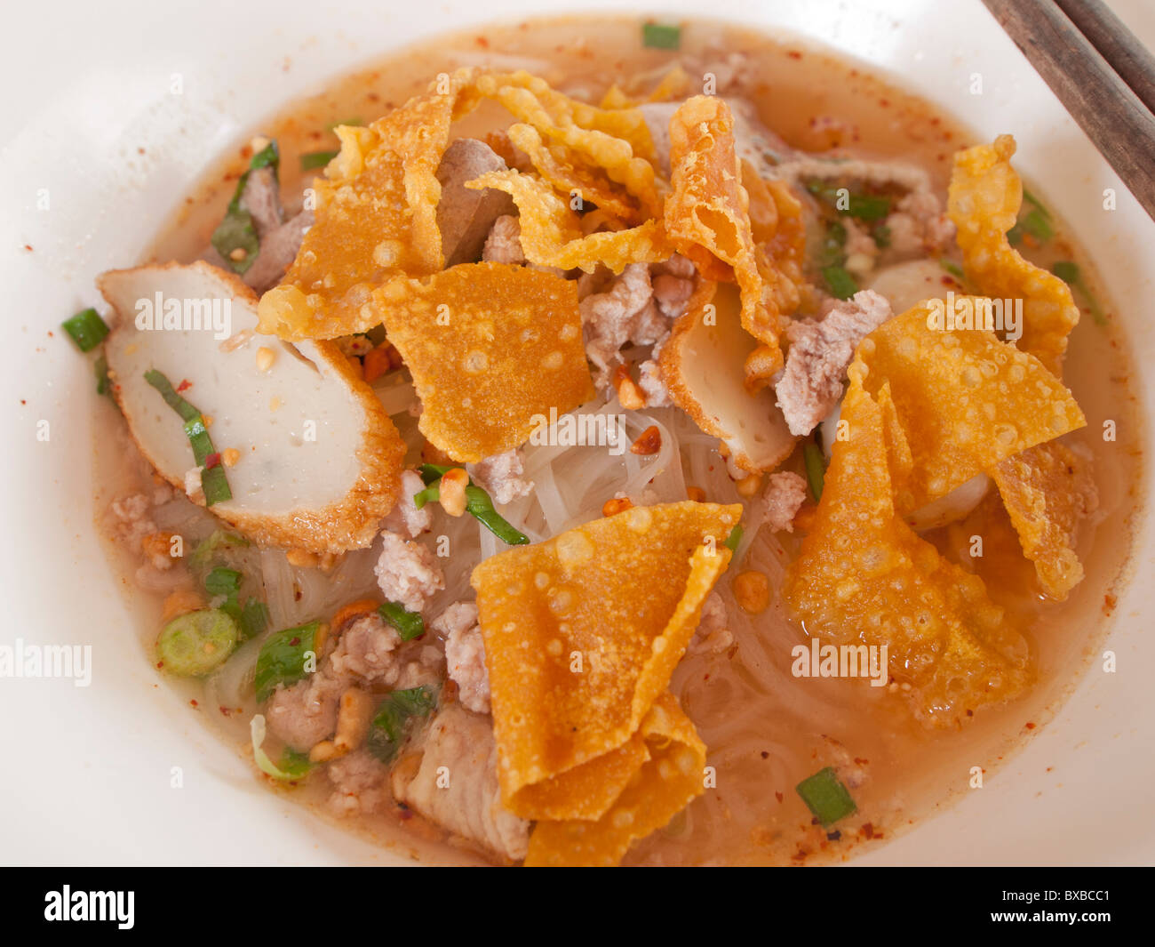 The white small noodles soup with minced pork, fish sausages and crisy wanton sheet. Stock Photo