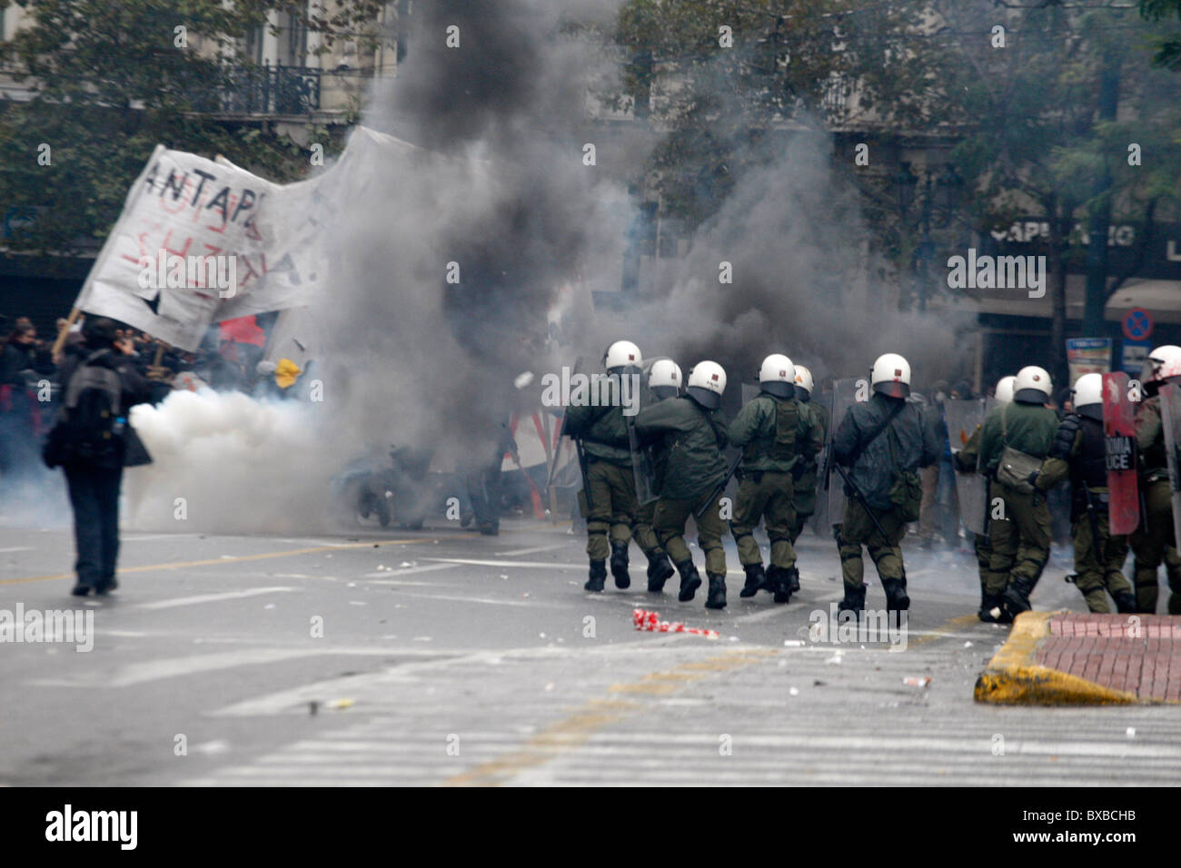 Protesters clash with the riot police, throw petrol bombs and stone against them. General strike in Greece as unions protest new labor reforms amid persisting austerity. Stock Photo