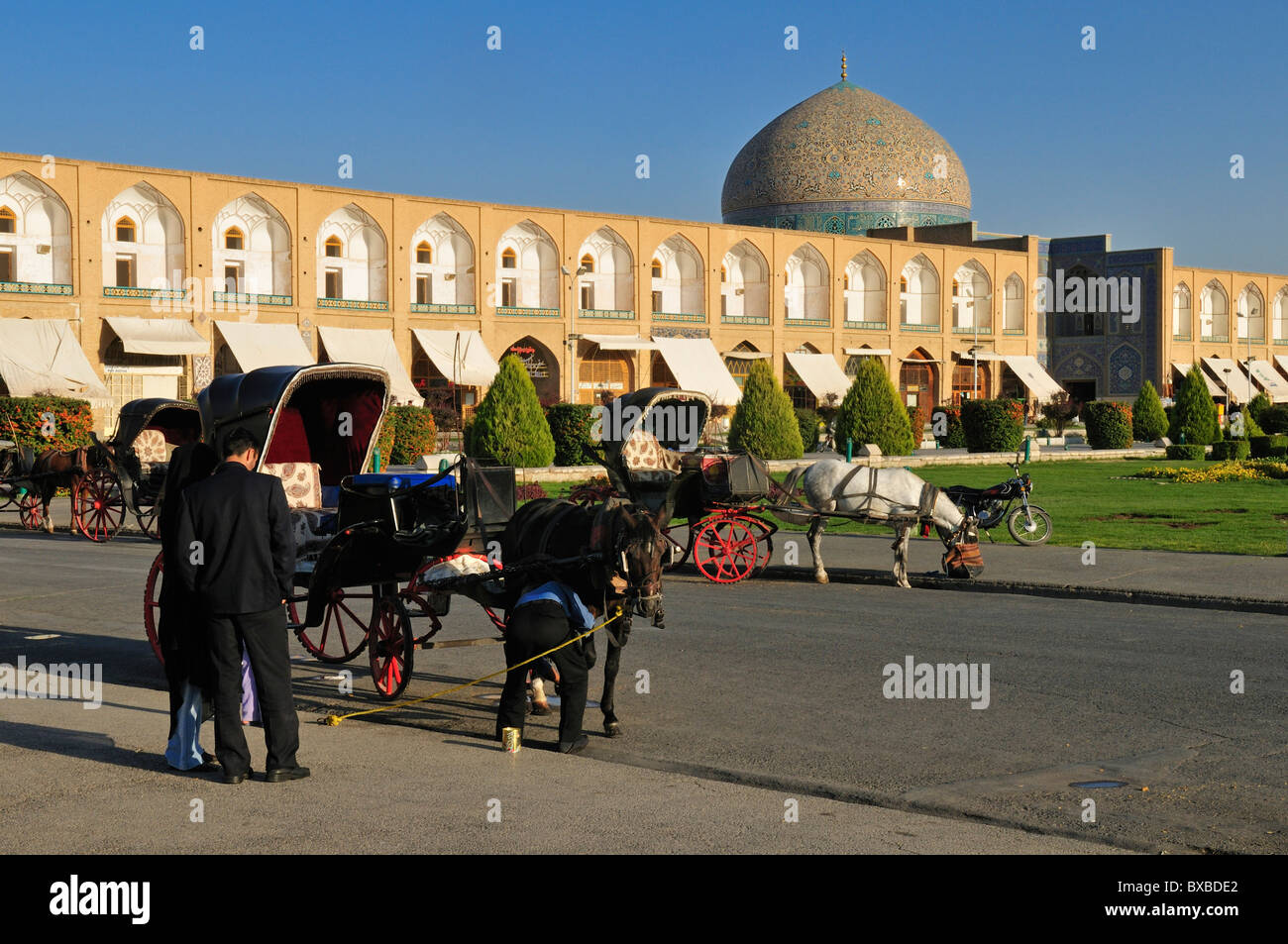 Horse drawn carriages on Meidan-e Emam, Naqsh-e Jahan, Imam Square with Sheik Lotfollah, Lotf Allah Mosque, Esfahan Stock Photo