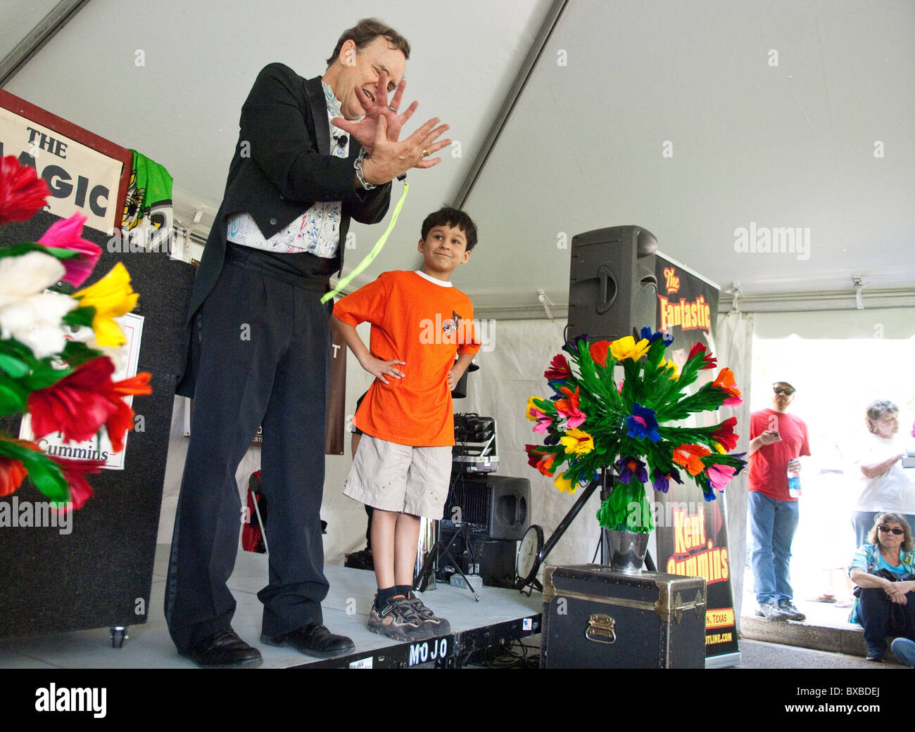 Magician with young boy selected from audience performs in children's entertainment tent at the Texas Book Festival in Austin Stock Photo