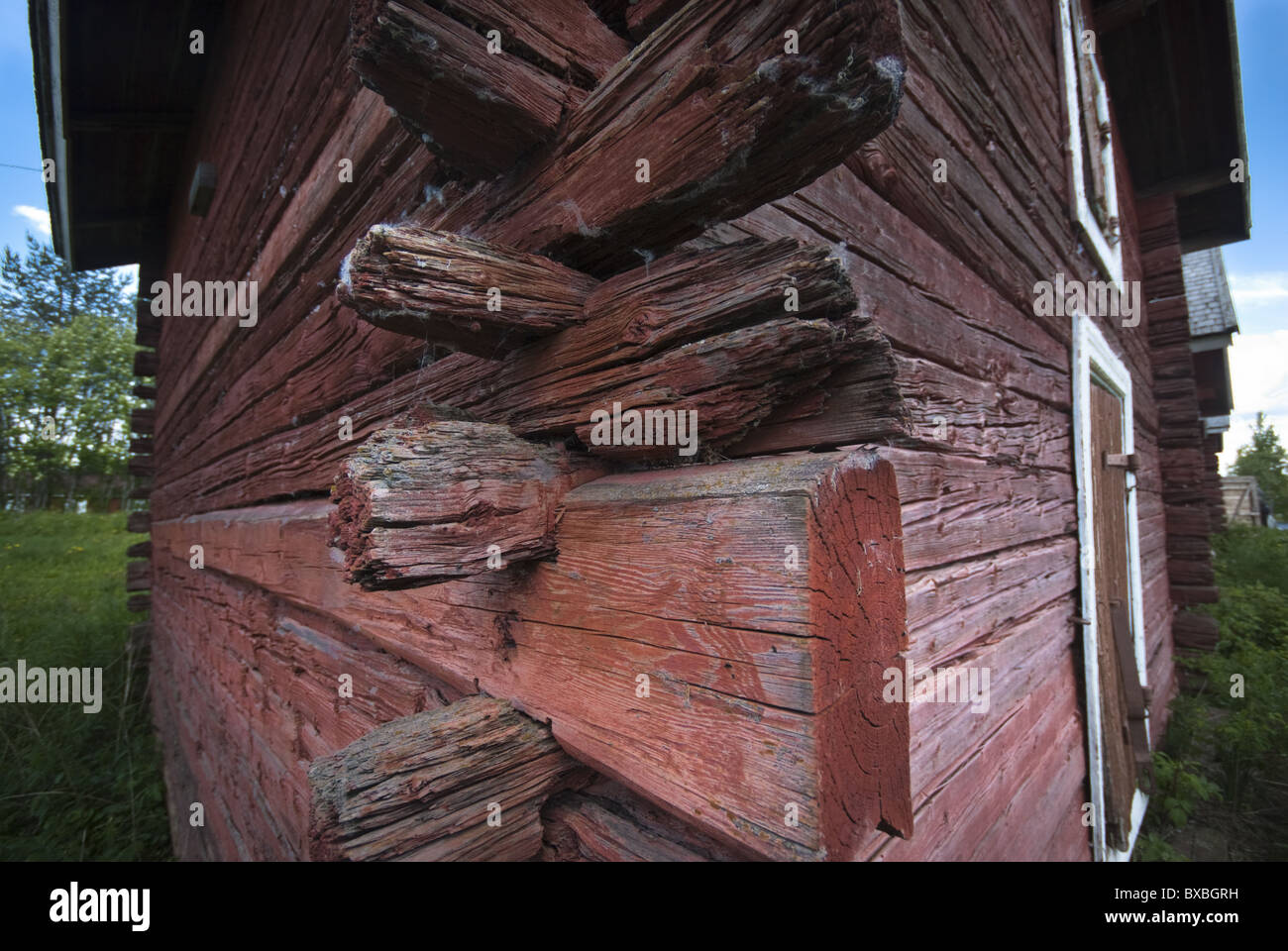 Corner of a traditional, rugged Finnish timbered house. The red color comes from natural red ocher paint . Stock Photo