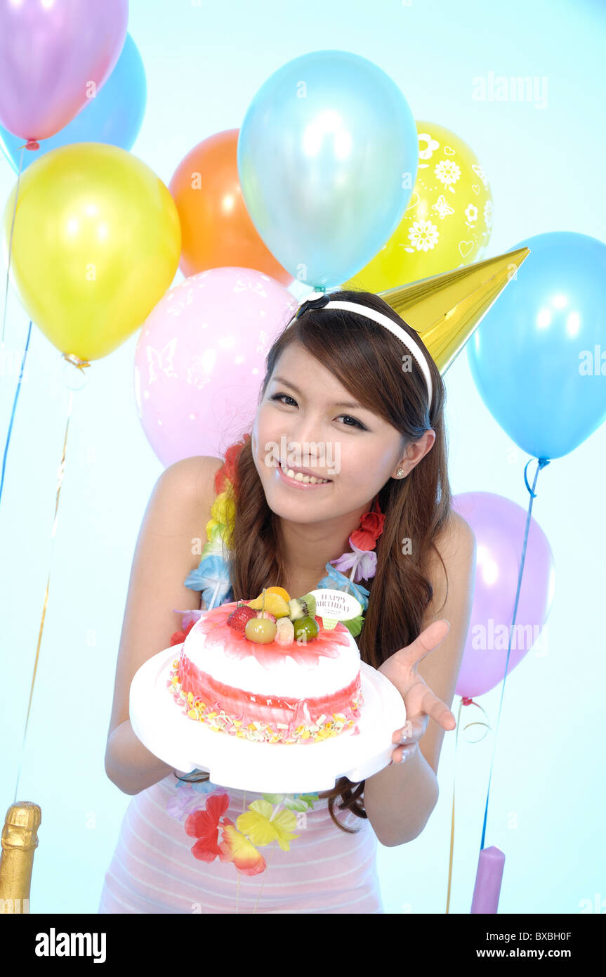 Woman holding a cake in a birthday party Stock Photo Alamy