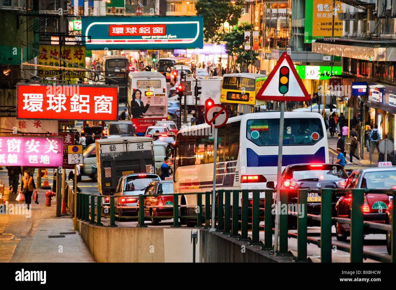 Buses and cars on evening commute on busy Hong Kong downtown street Stock Photo
