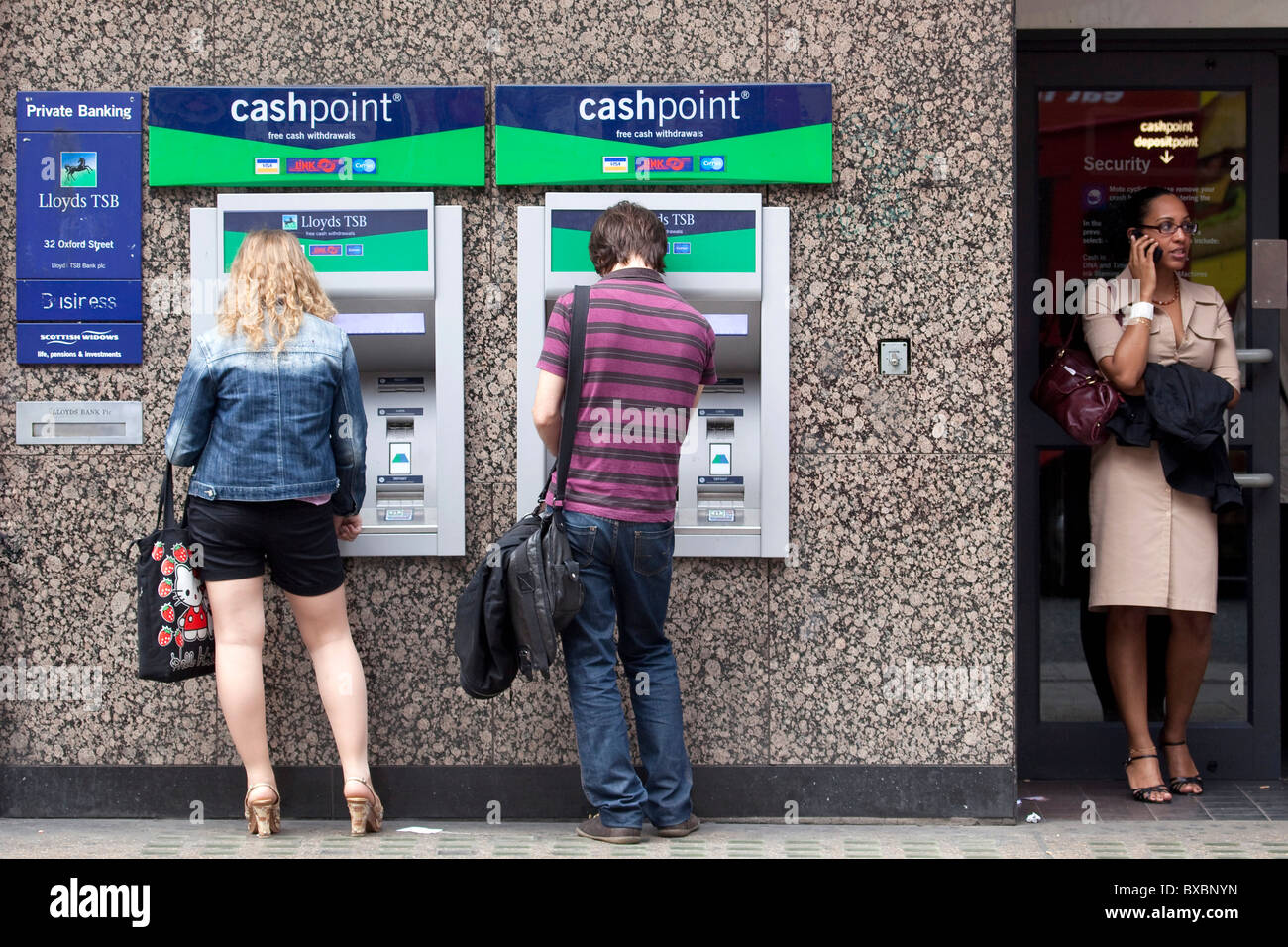 Woman and man at the cash machines of the Lloyds TSB Bank in London, England, United Kingdom, Europe Stock Photo