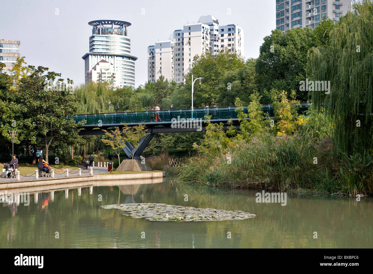 Lake with bridge and buildings in background, Xujiahui Park, Shanghai, China Stock Photo