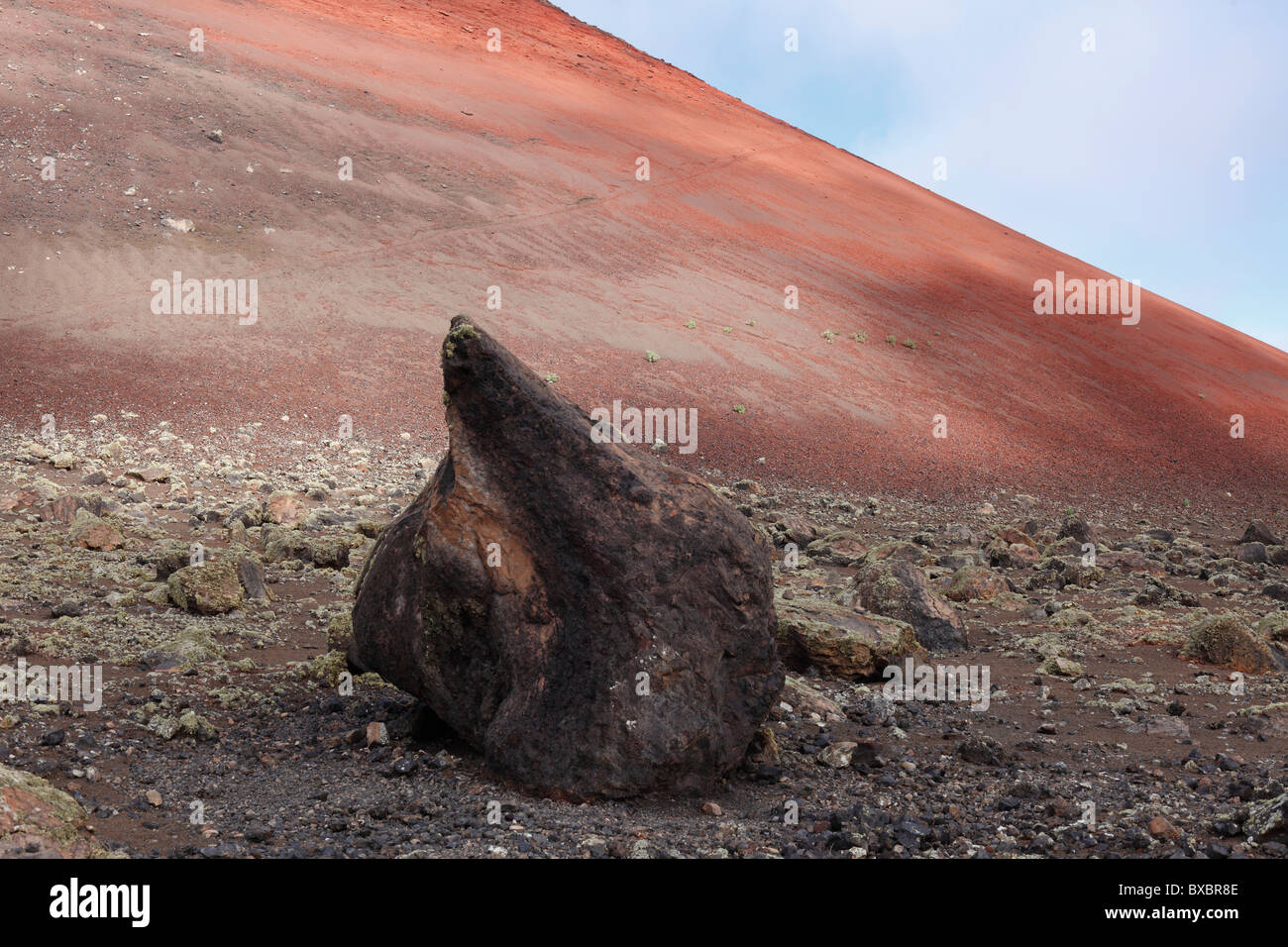 Volcanic bomb in front of Montaña Colorada volcano, Lanzarote, Canary Islands, Spain, Europe Stock Photo