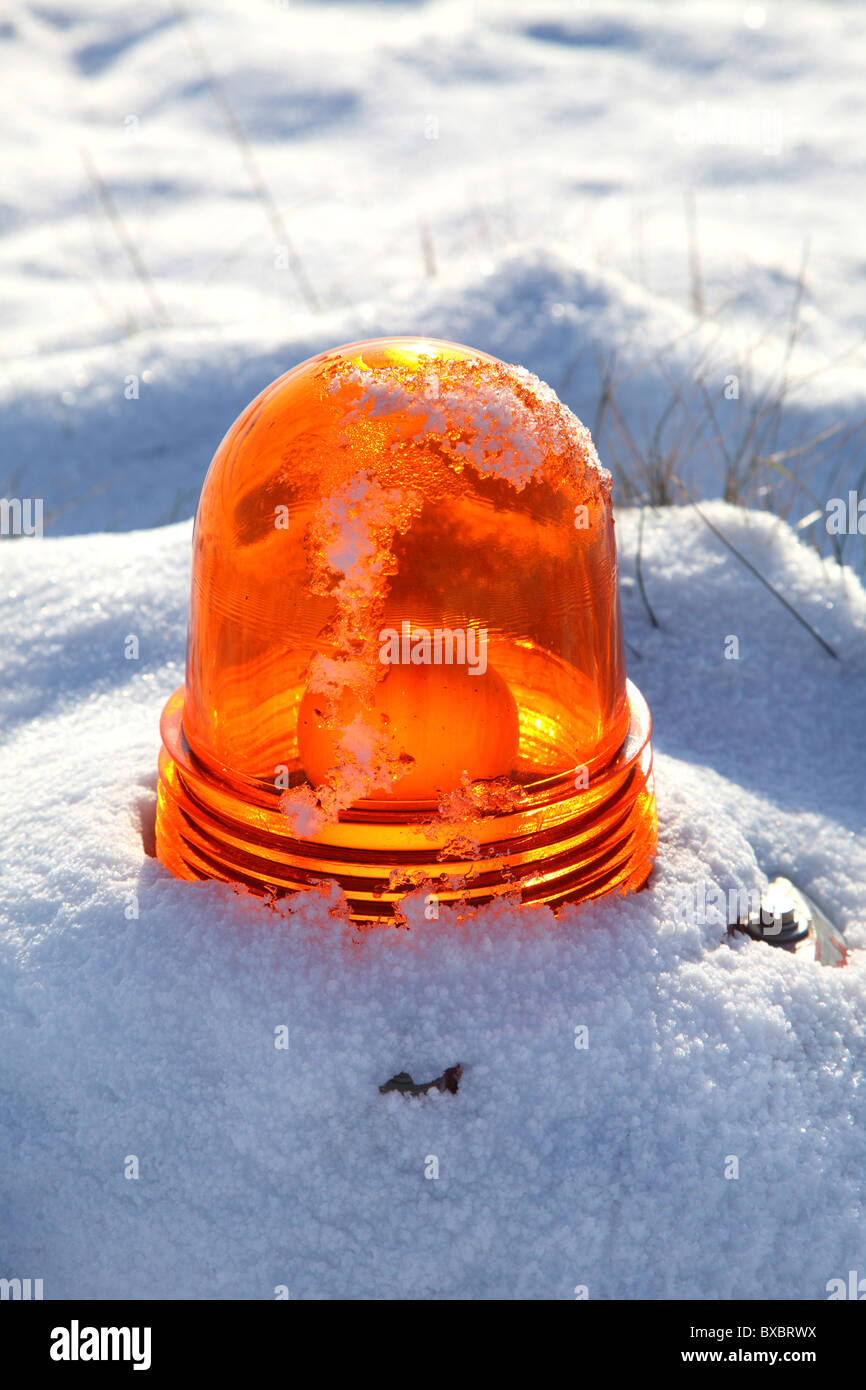 Orange warning light on an airport, covered in snow. Stock Photo