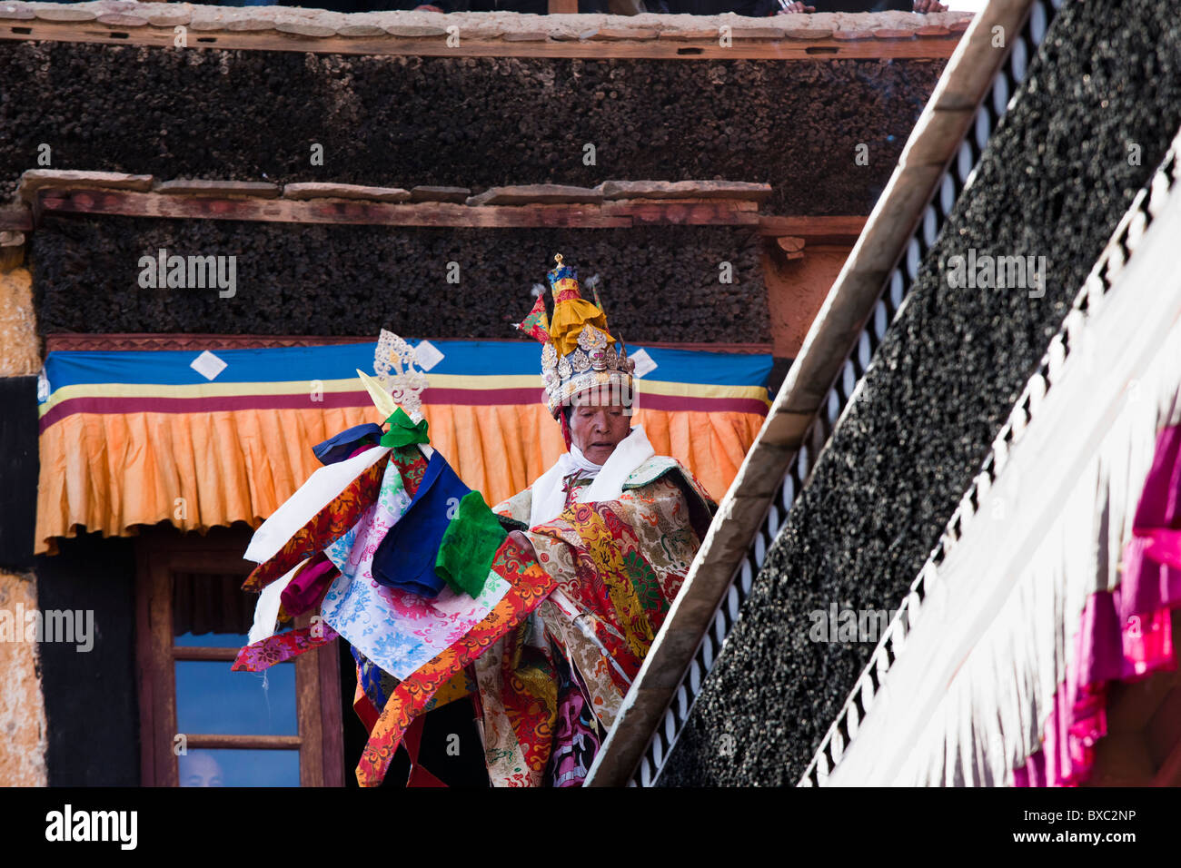 A Buddhist oracle dancing in trance on a ledge in the Thiksey monastery in Ladakh Stock Photo