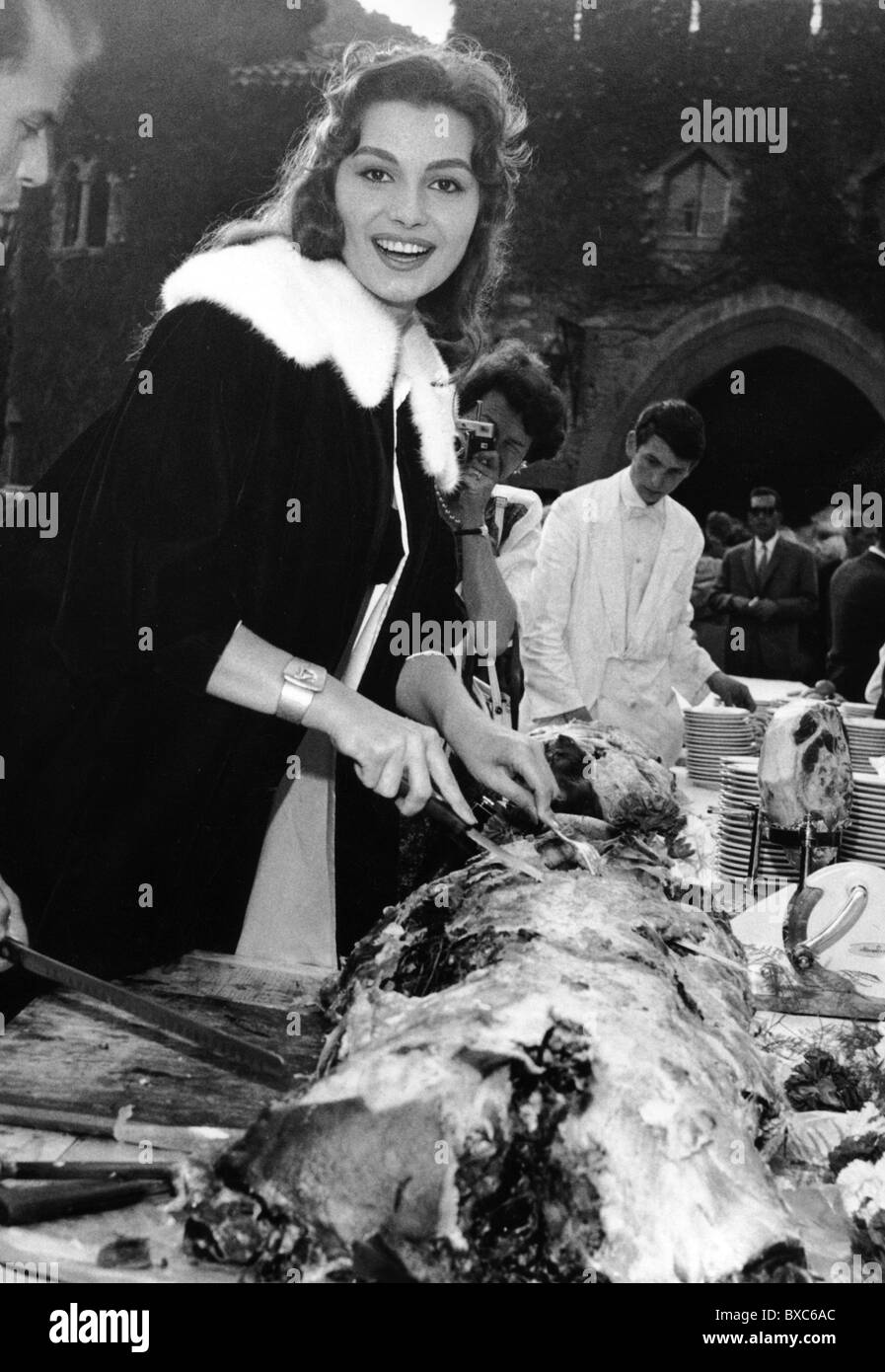 Schiaffino, Rosanna, 25.11.1939 - 17.10.2009, Italian actress, half length, carving a suckling pig, circa 1960s, Stock Photo