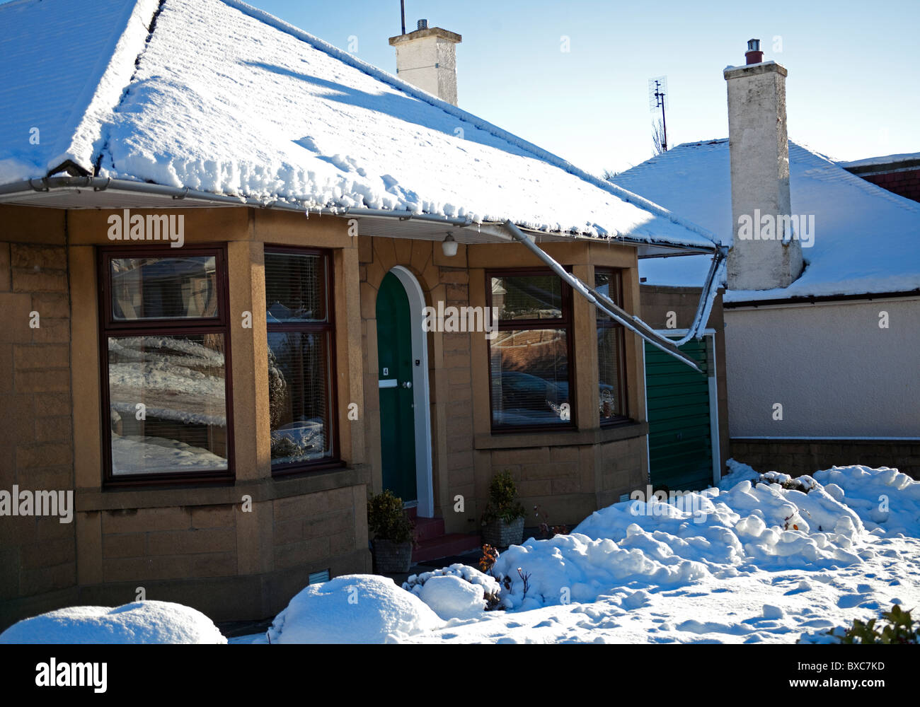 Winter Snow damage, collapsed roof guttering due to icy weather conditions Stock Photo