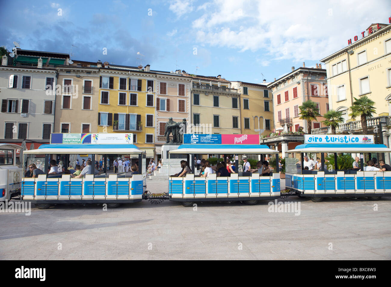 The blue tourist tram or train that shows tourists around the highlights and tourist attractions of Salo, Province of Brescia in Italy Stock Photo