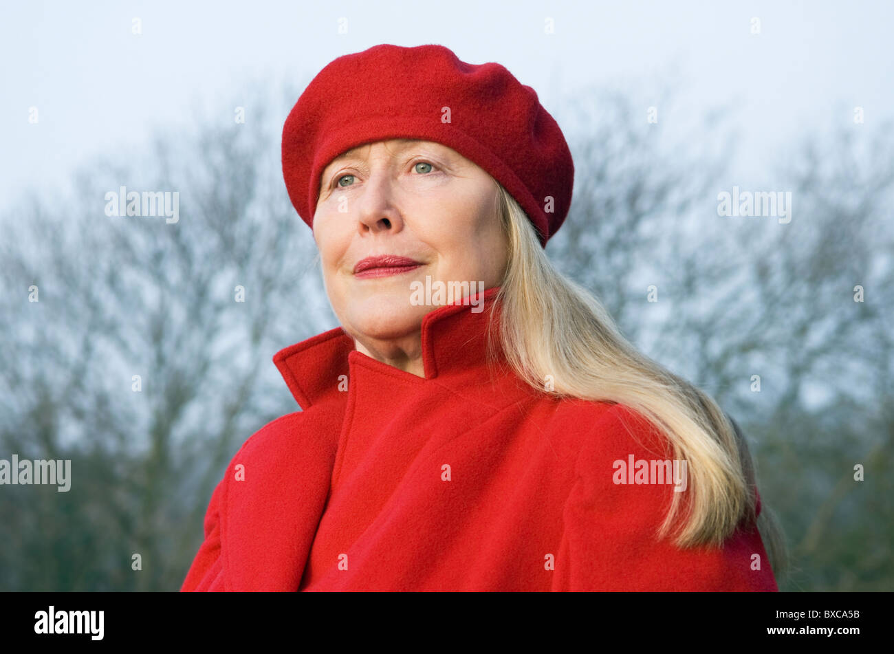 A beautiful older woman in her sixties wearing a red winter coat and beret Stock Photo Alamy
