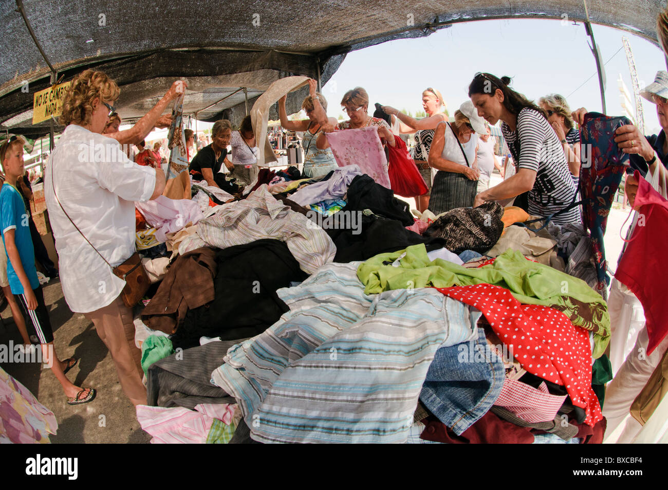 stall with cheap used clothing in spanish outdoor market Stock Photo