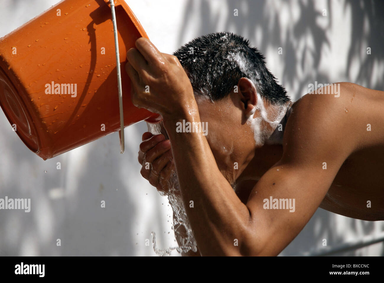 Luang Prabang is full of young monks, here is a head washed with a bucket of water Stock Photo