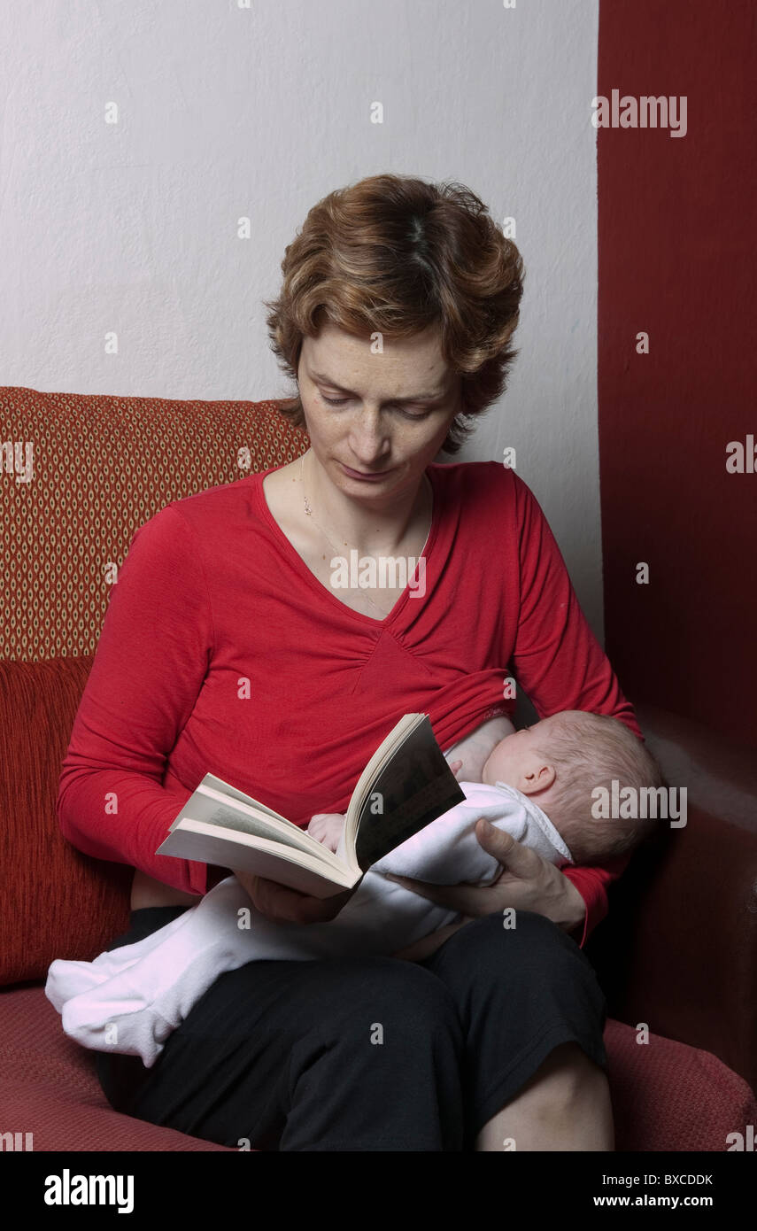 A mother breastfeeding while reading Stock Photo Alamy