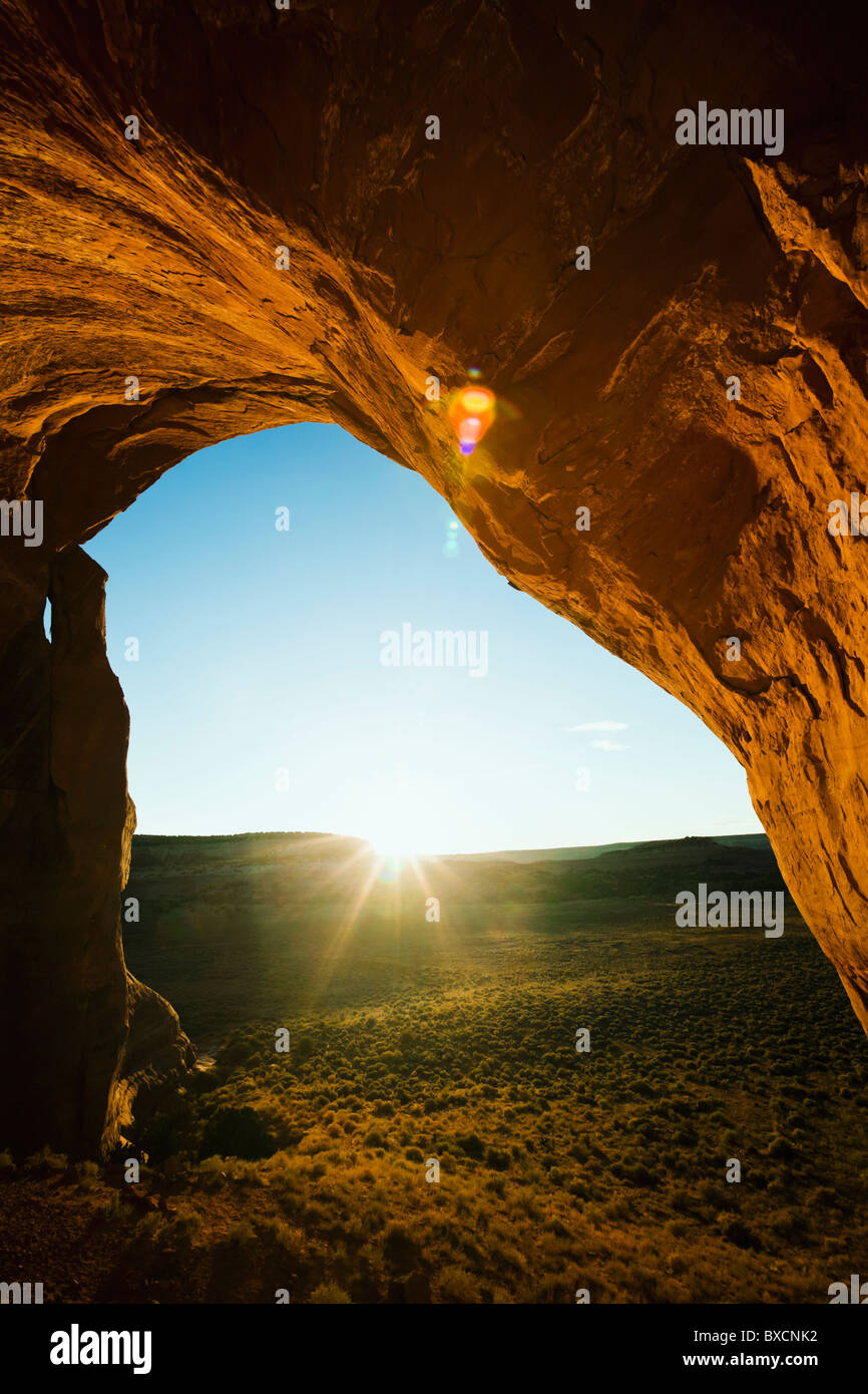 A view of sunrise looking out from Looking Glass Arch in Southeast Utah, USA. Stock Photo