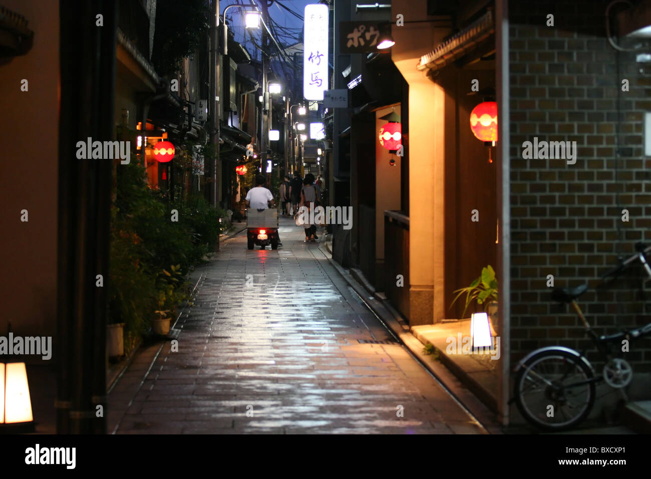 Glowing paper lanterns hung outside restaurants in a narrow alley in Gion district, Kyoto, Japan