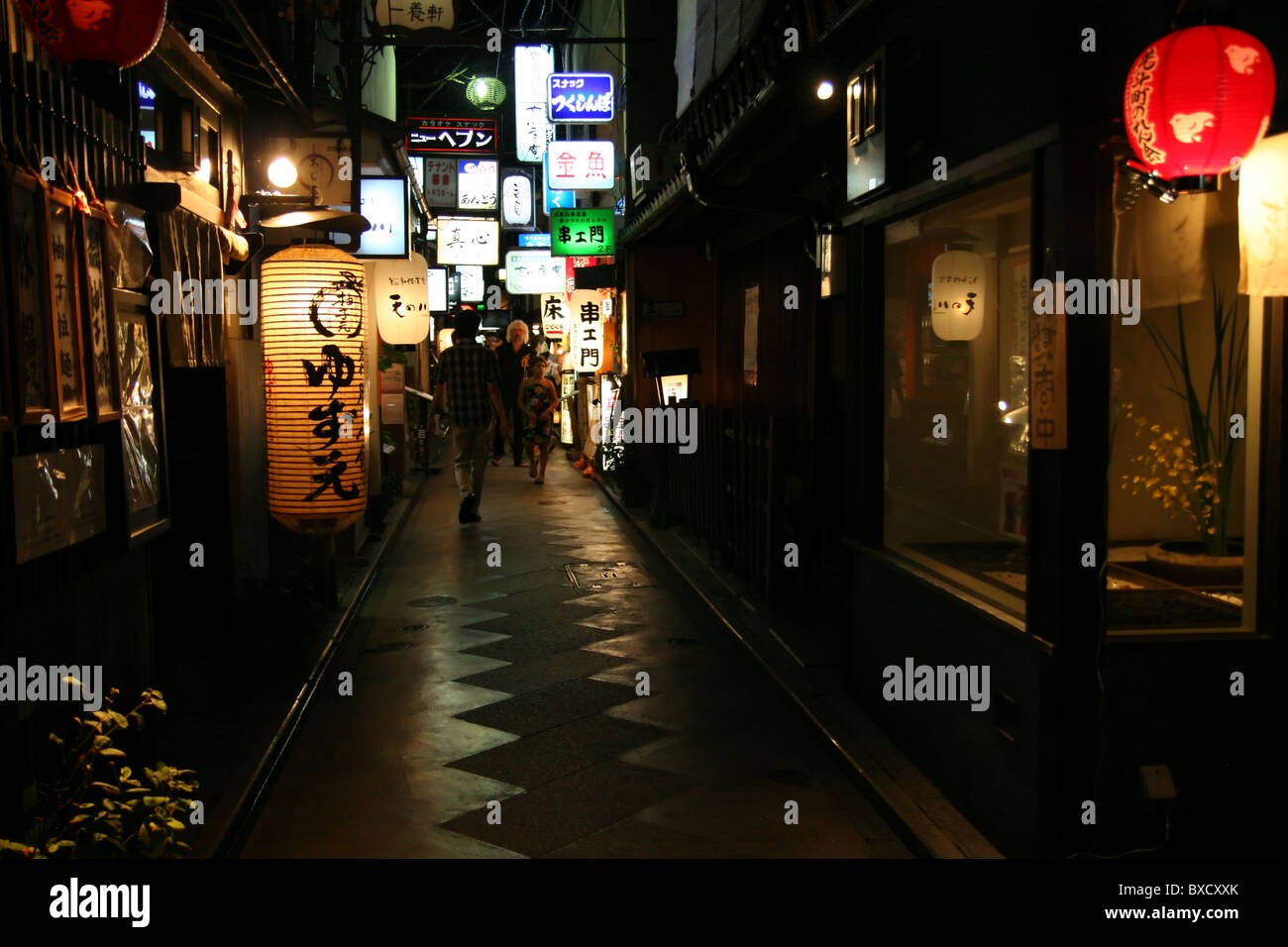 Glowing paper lanterns hung outside restaurants in a narrow alley in Gion district, Kyoto, Japan