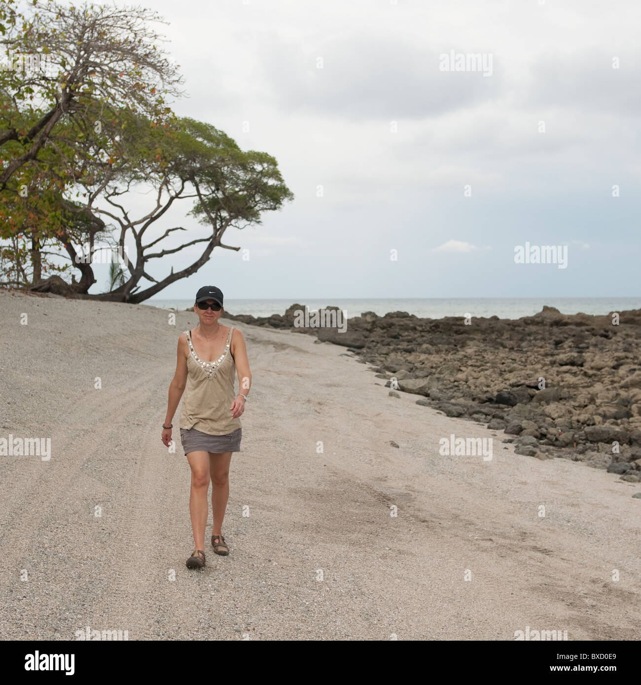 Woman walking along coastal road in Costa Rica Stock Photo