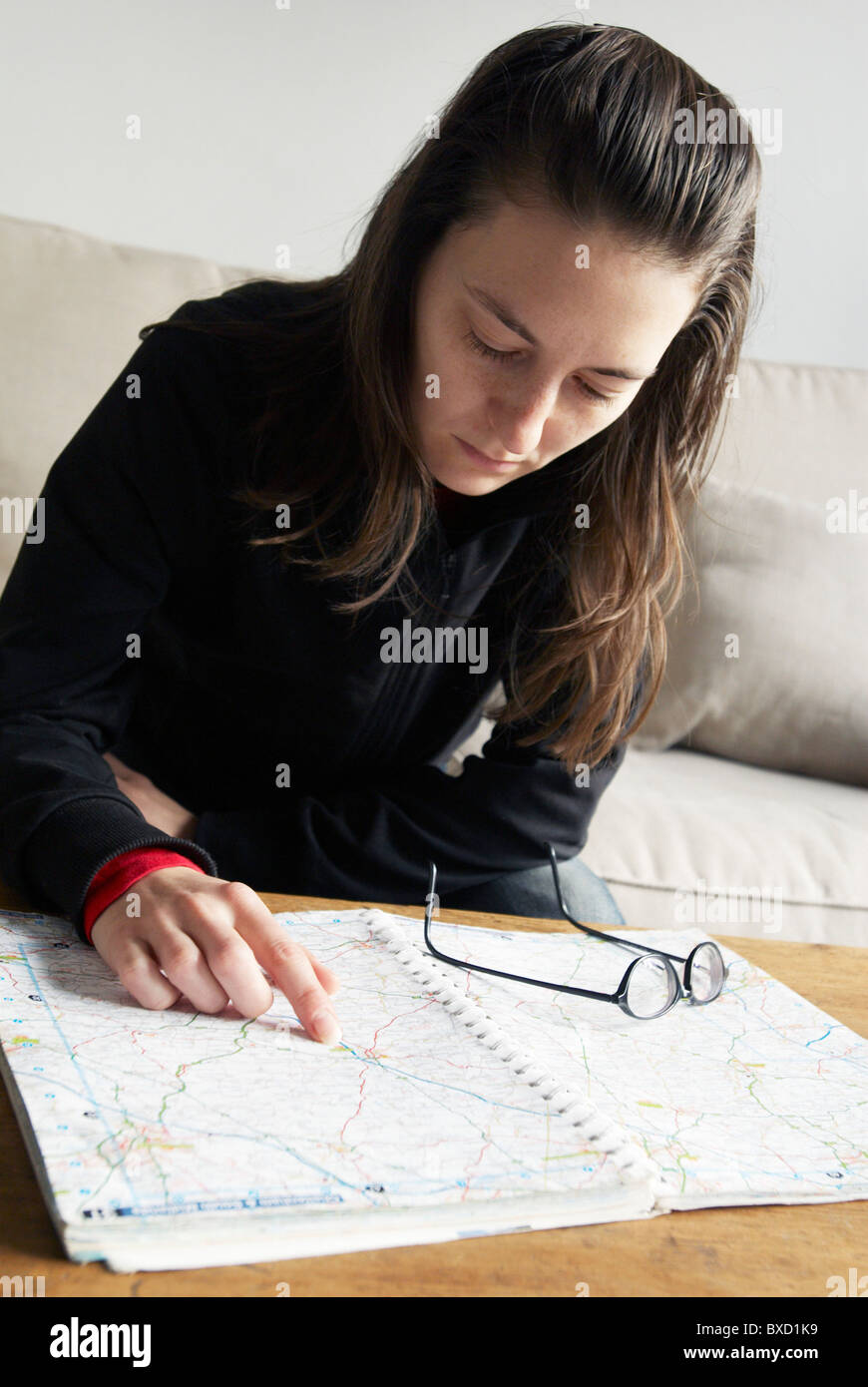 Woman looking up directions in a roadmap Stock Photo