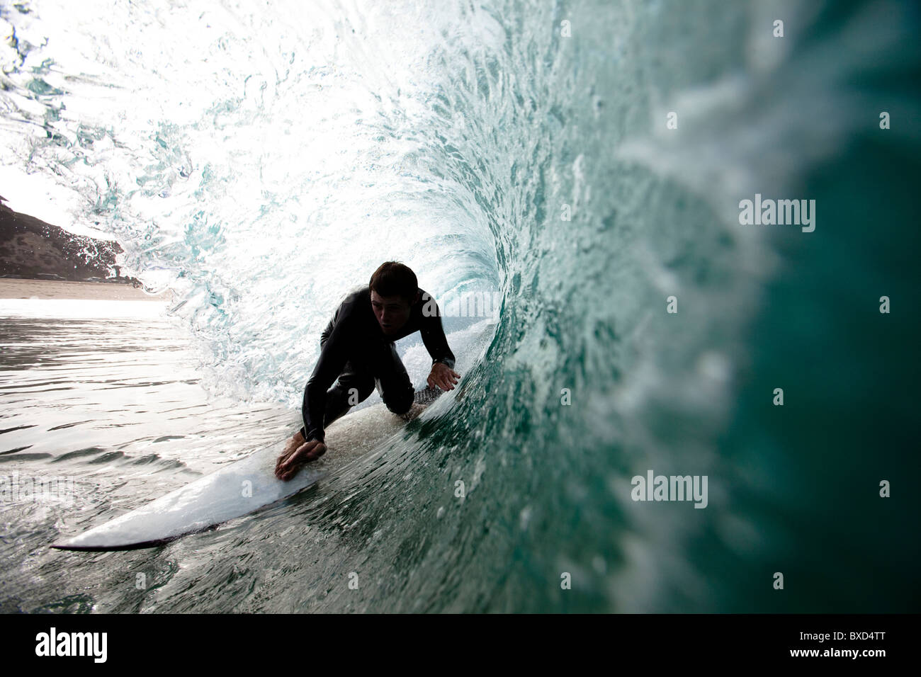 A male surfer navigates the barrel while surfing at Westward in Malibu, California. Stock Photo