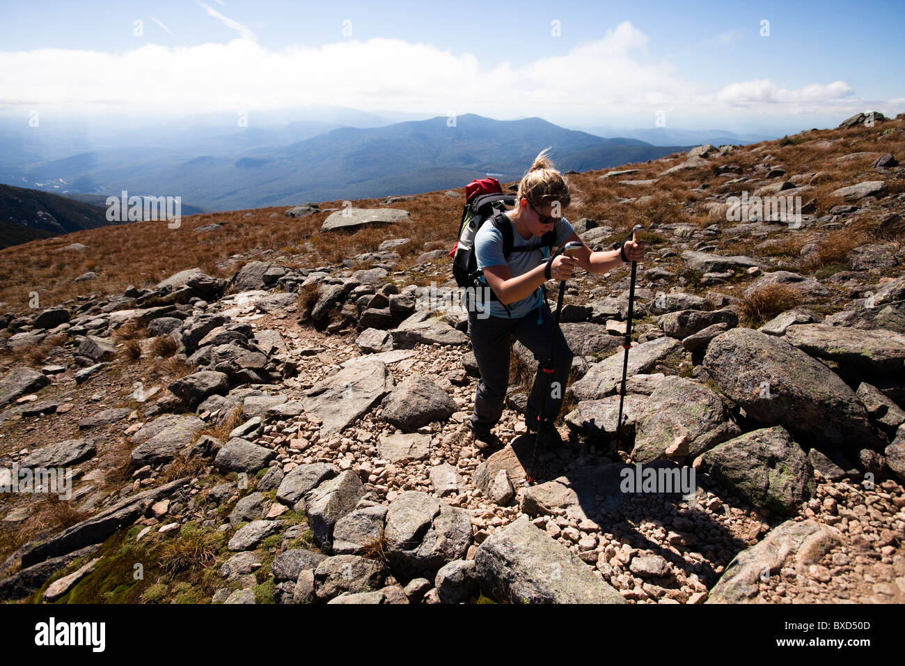 An athletic female hiker hikes the Franconia Ridge Trail. Stock Photo