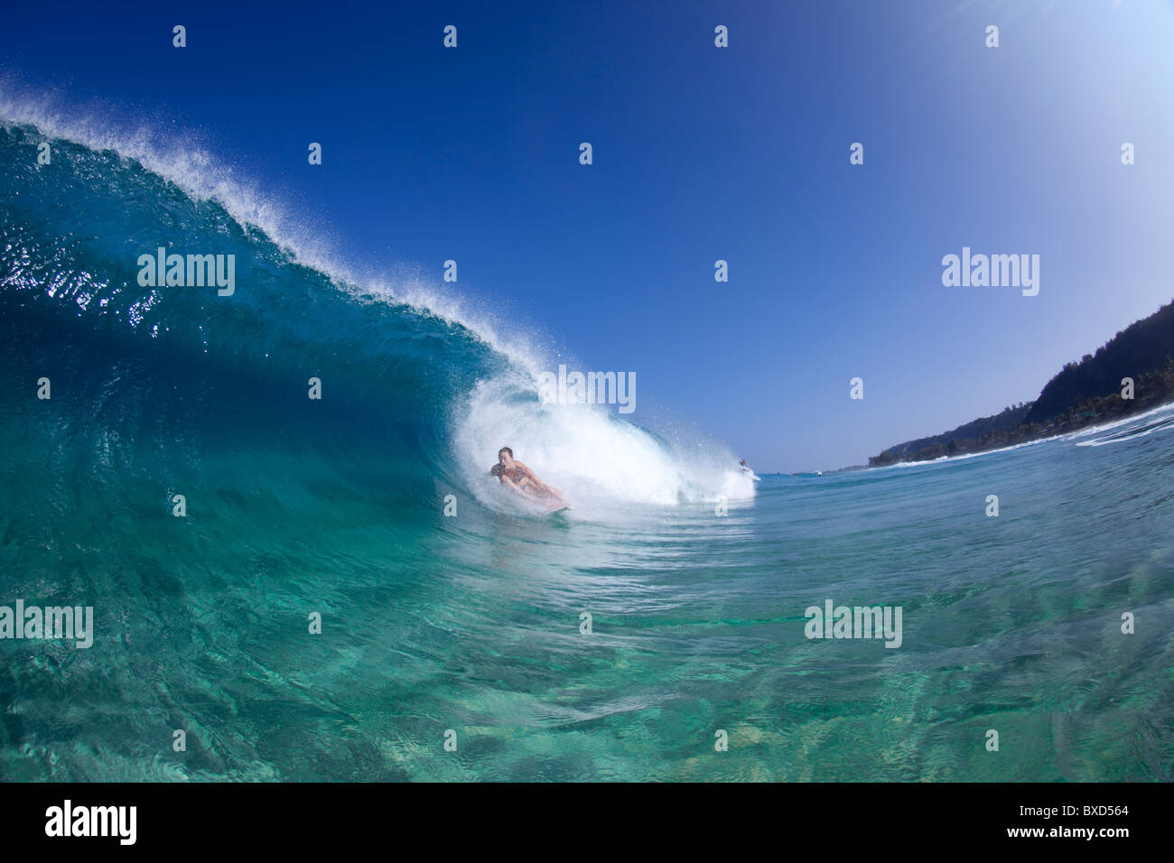 A water view of a surfer girl in the tube, in Hawaii. Stock Photo