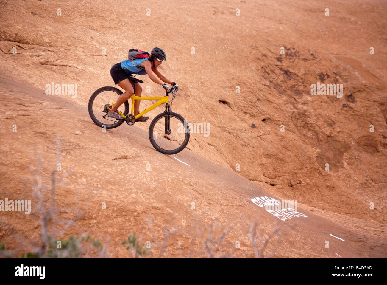 A woman mountain bikes one of the Slick Rock routes in Moab Utah Stock