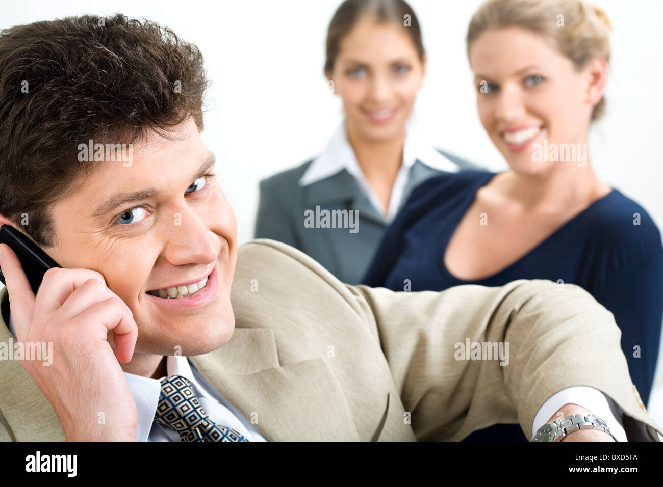 Business man looks at camera while calls by phone Stock Photo