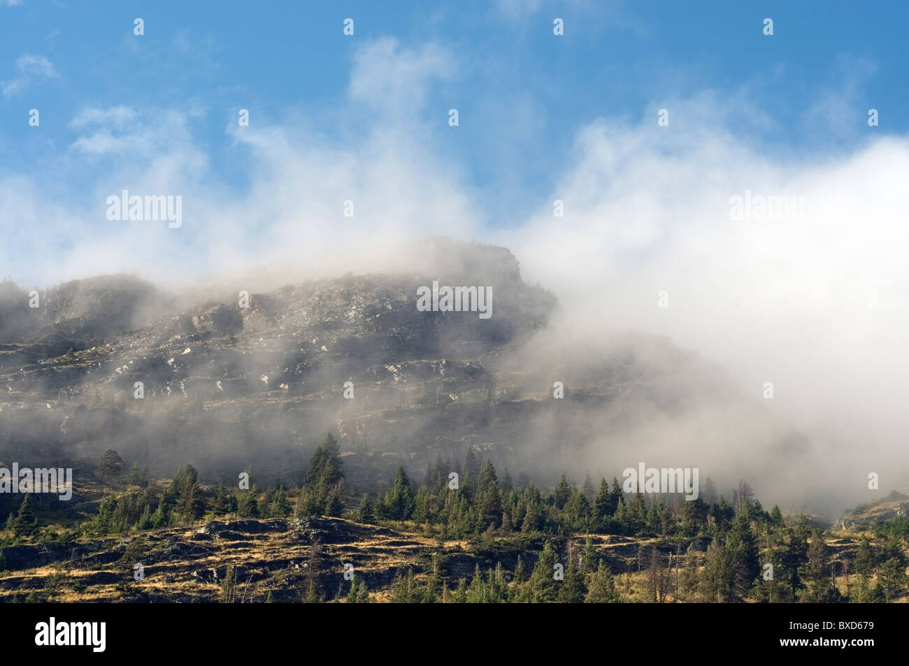 Scenic view of mountain shrouded in wispy clouds Stock Photo - Alamy